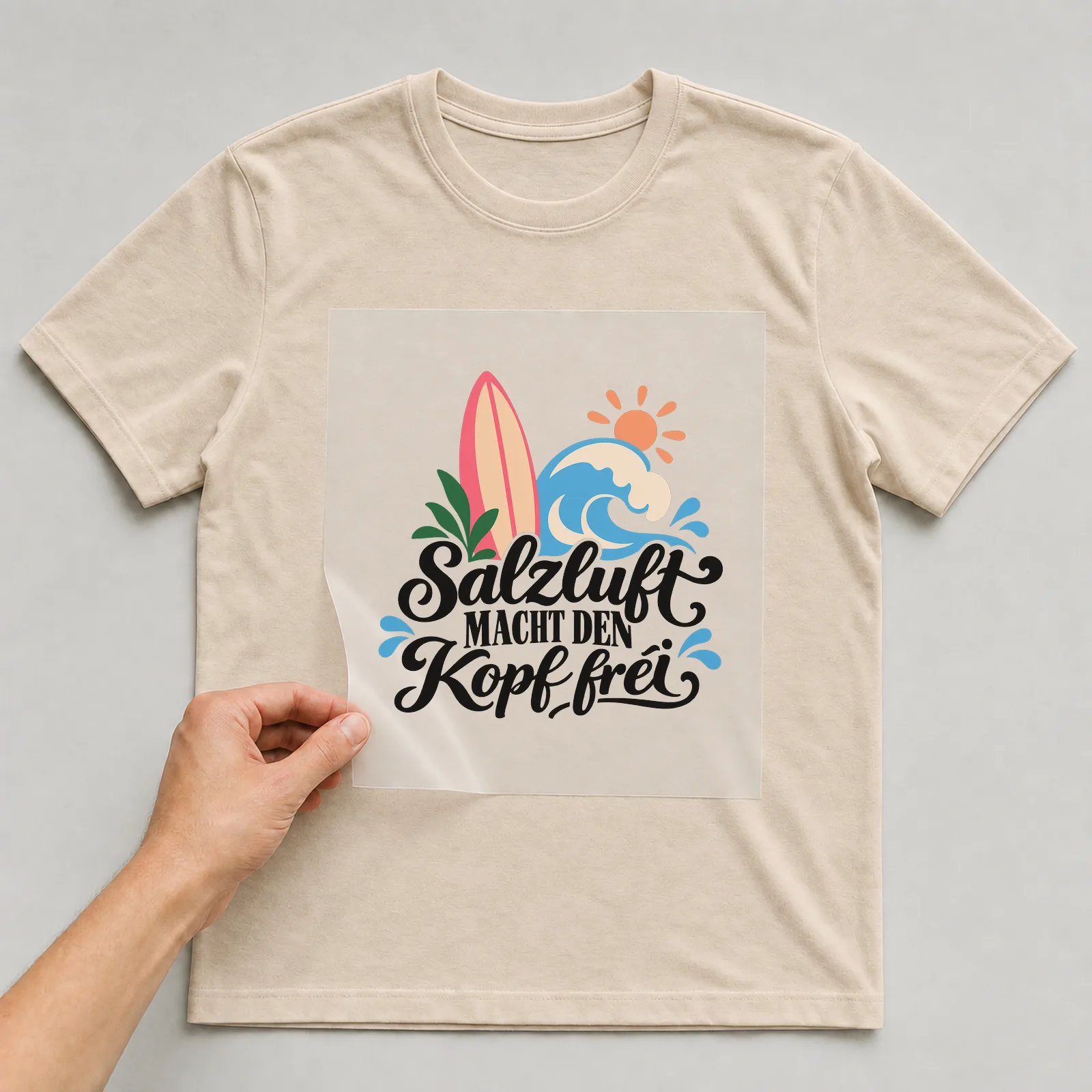 Bügelbild „Salzluft macht den Kopf frei“ auf beigem T-Shirt, Folie wird aufgelegt