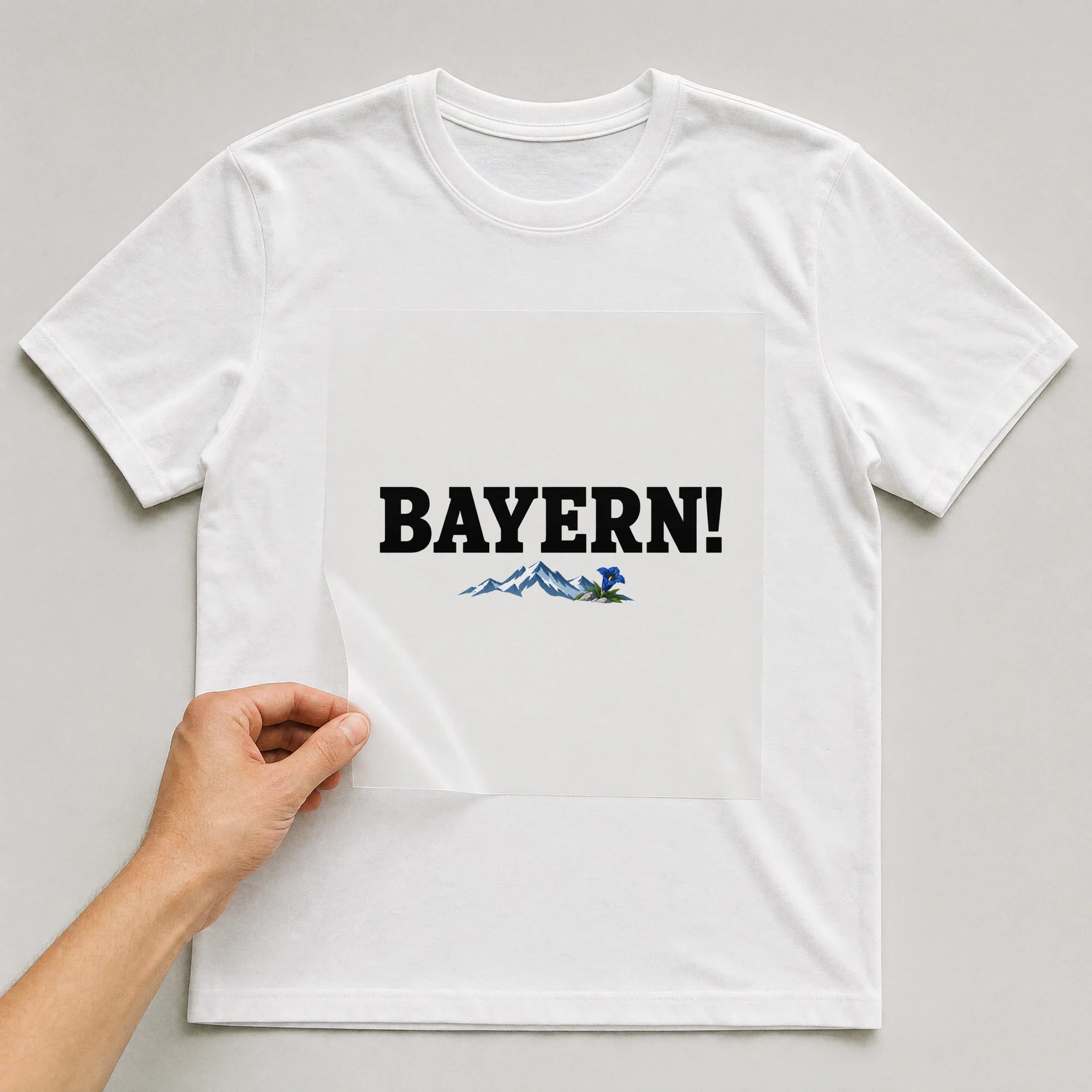 Bügelbild „Bayern!“ auf weißem T-Shirt, Folie wird aufgelegt