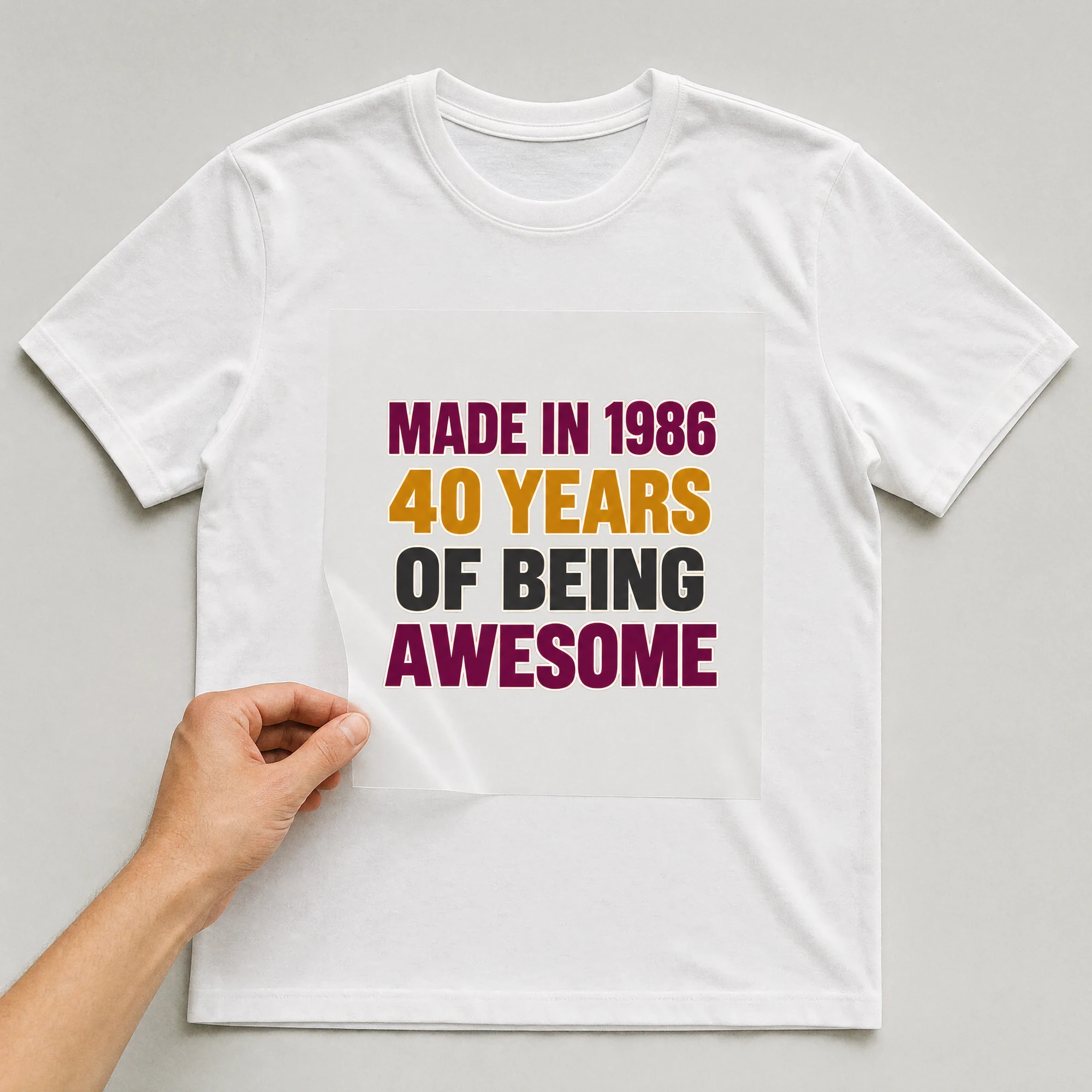 Bügelbild „MADE IN 1986 40 YEARS OF BEING AWESOME“ auf weißem T-Shirt, Folie wird aufgelegt