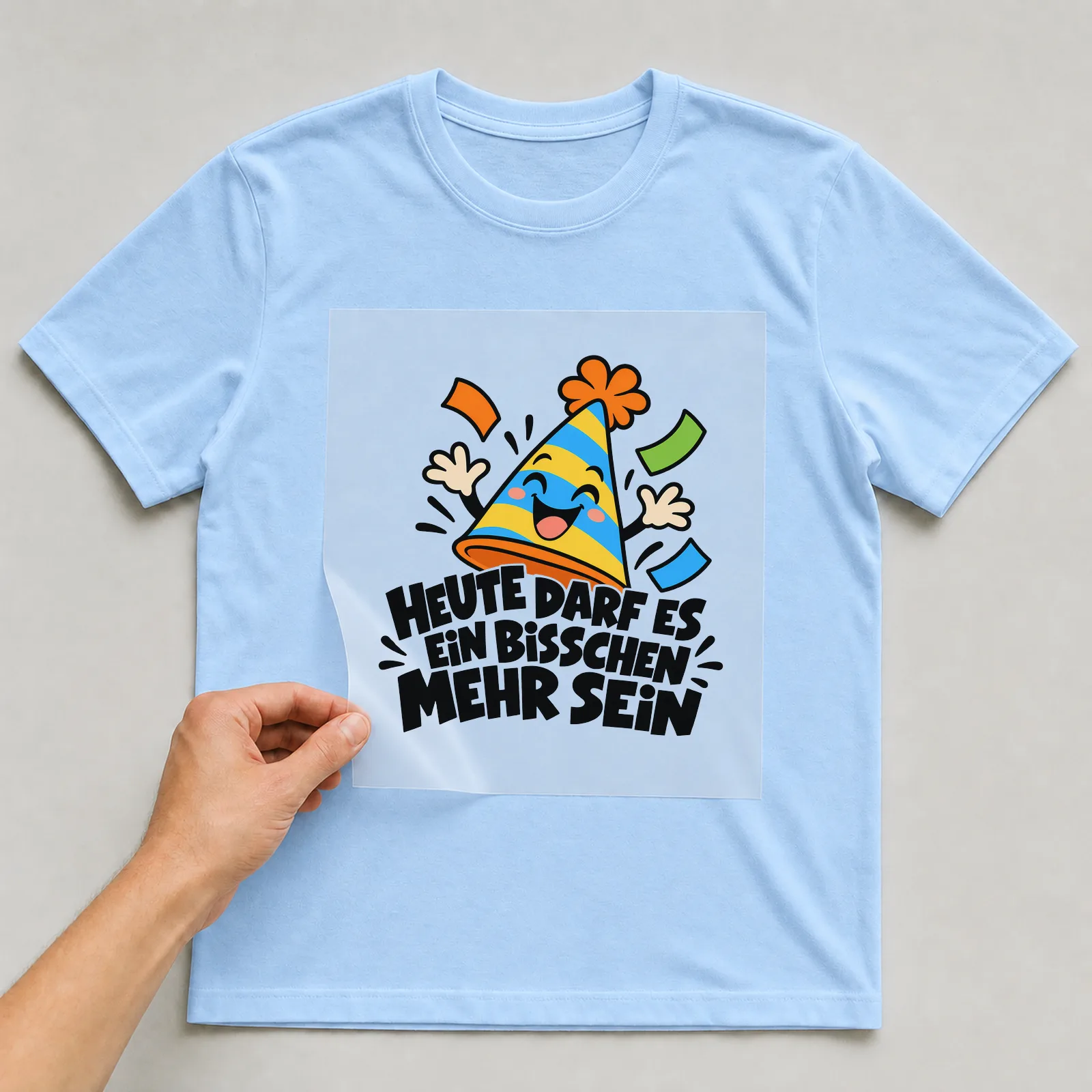 Bügelbild „Heute darf es ein Bisschen mehr sein“ auf hellblauem T-Shirt, Folie wird aufgelegt