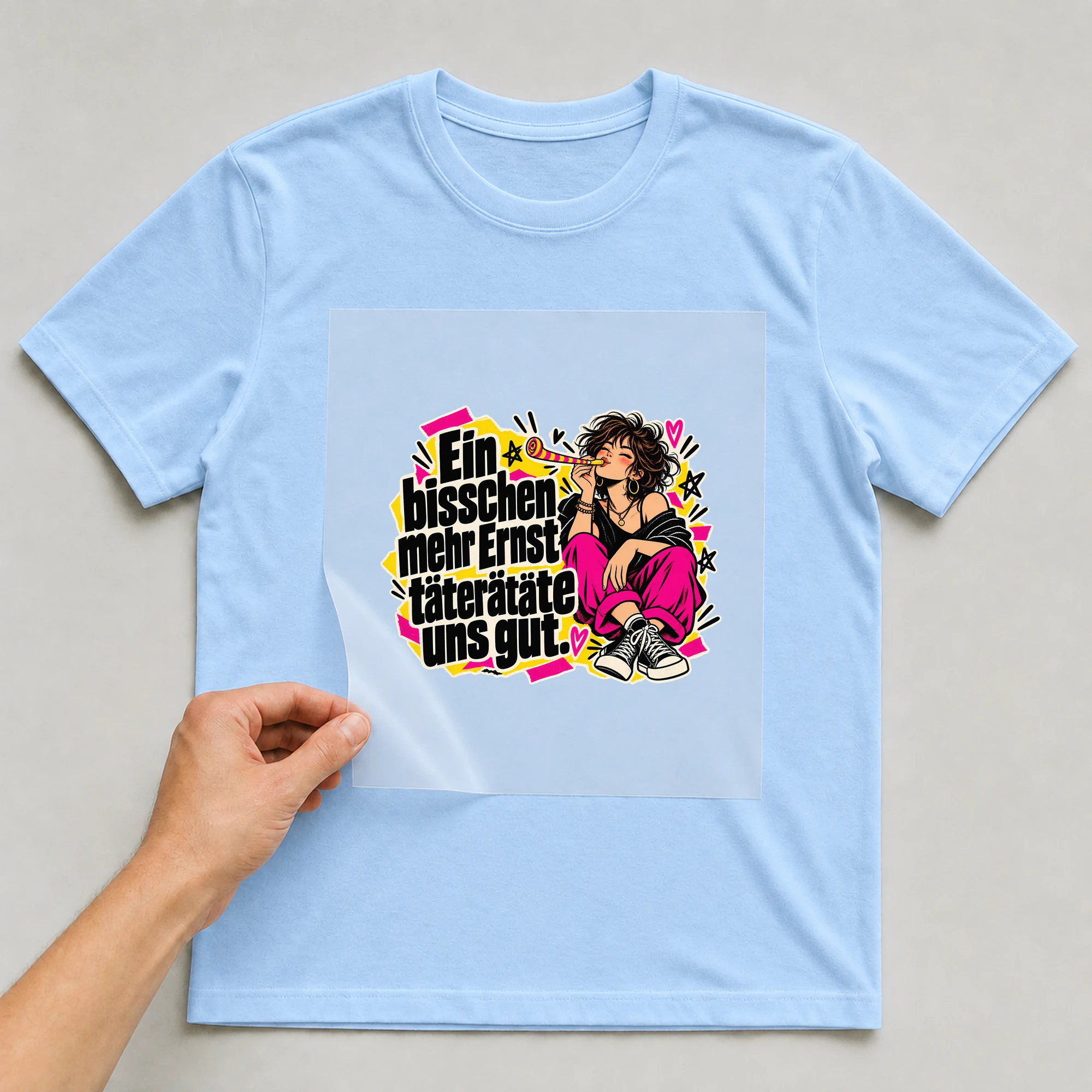 Bügelbild „Ein bisschen mehr Ernst täterätäte uns gut.“ auf babyblauem T-Shirt, Folie wird aufgelegt