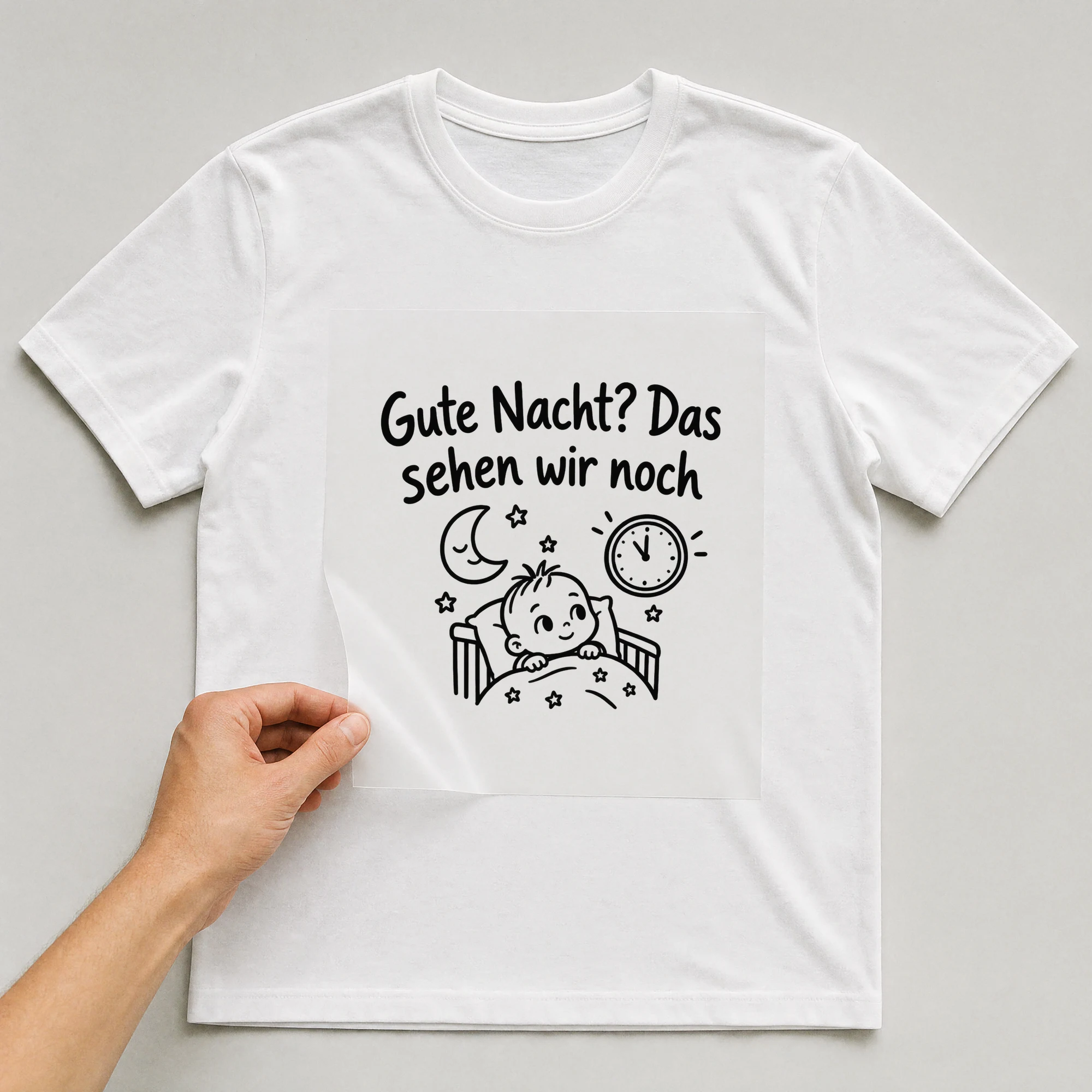 Bügelbild „Gute Nacht? Das sehen wir noch“ auf weißem T-Shirt, Folie wird aufgelegt