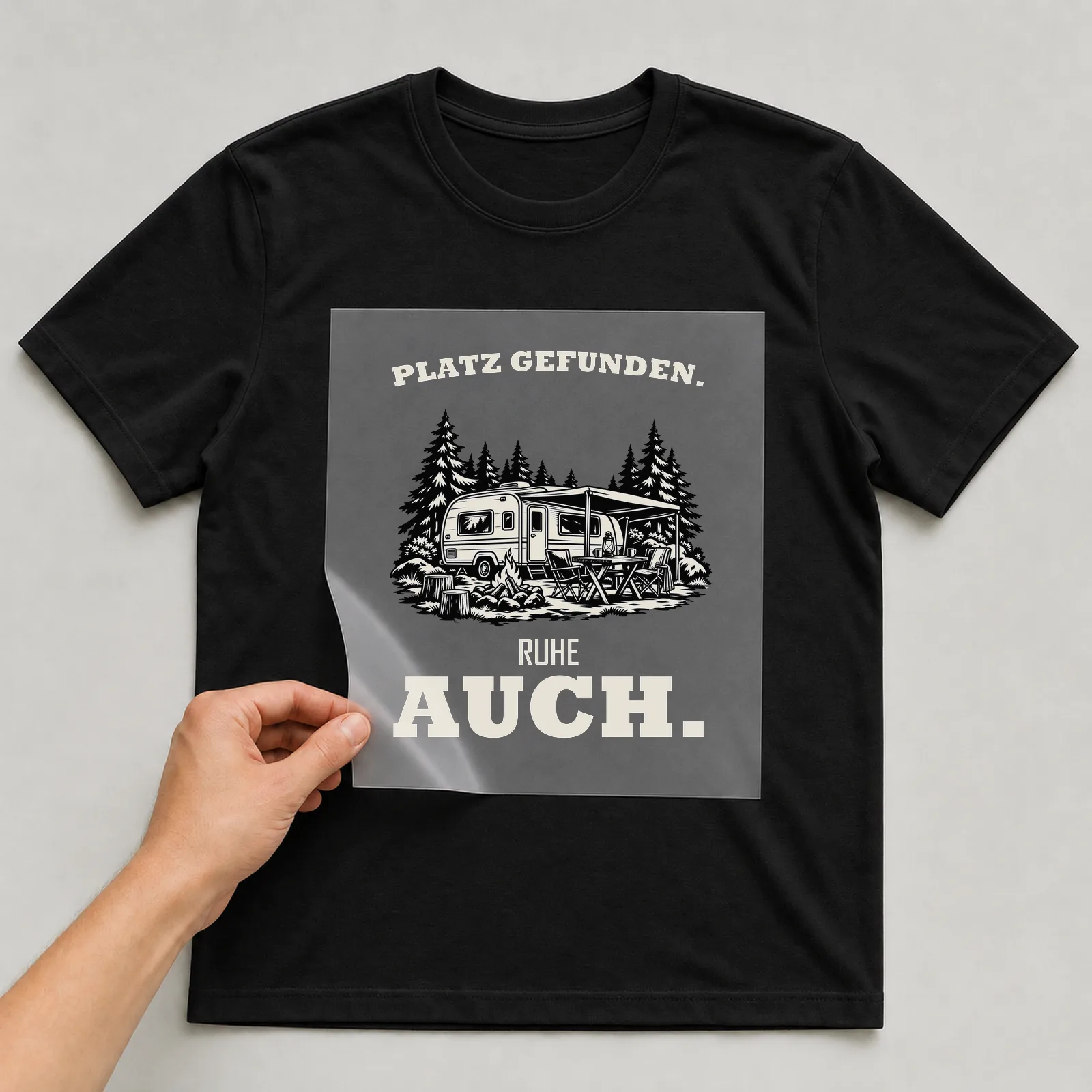 Bügelbild „Platz gefunden. Ruhe auch.“ auf schwarzem T-Shirt, Folie wird aufgelegt