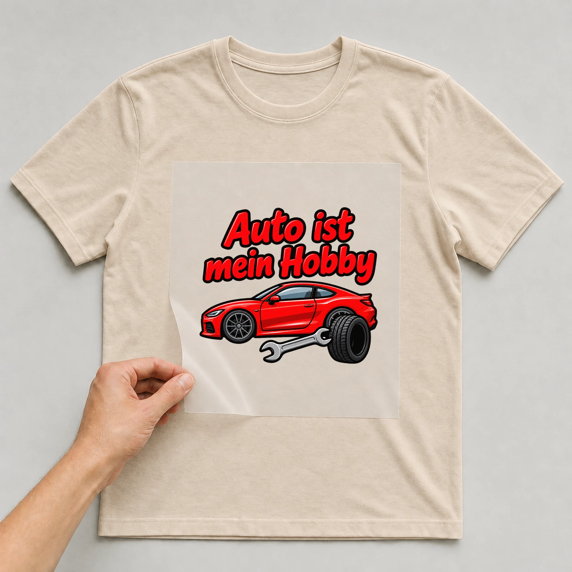 Bügelbild „Auto ist mein Hobby“ auf beigem T-Shirt, Folie wird aufgelegt