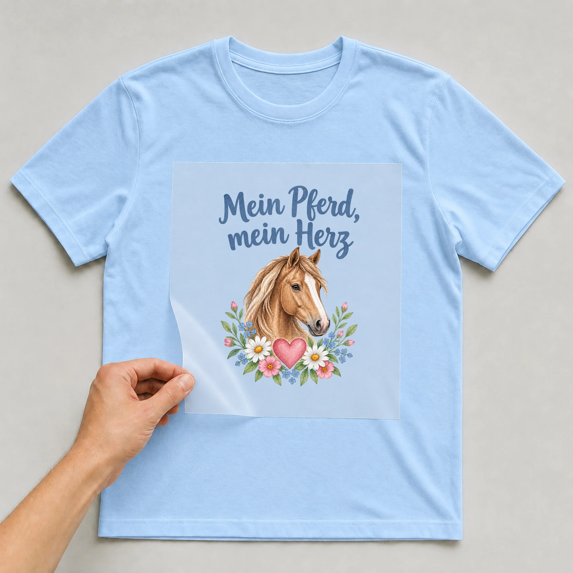 Bügelbild „Mein Pferd, mein Herz“ auf babyblauem T-Shirt, Folie wird aufgelegt
