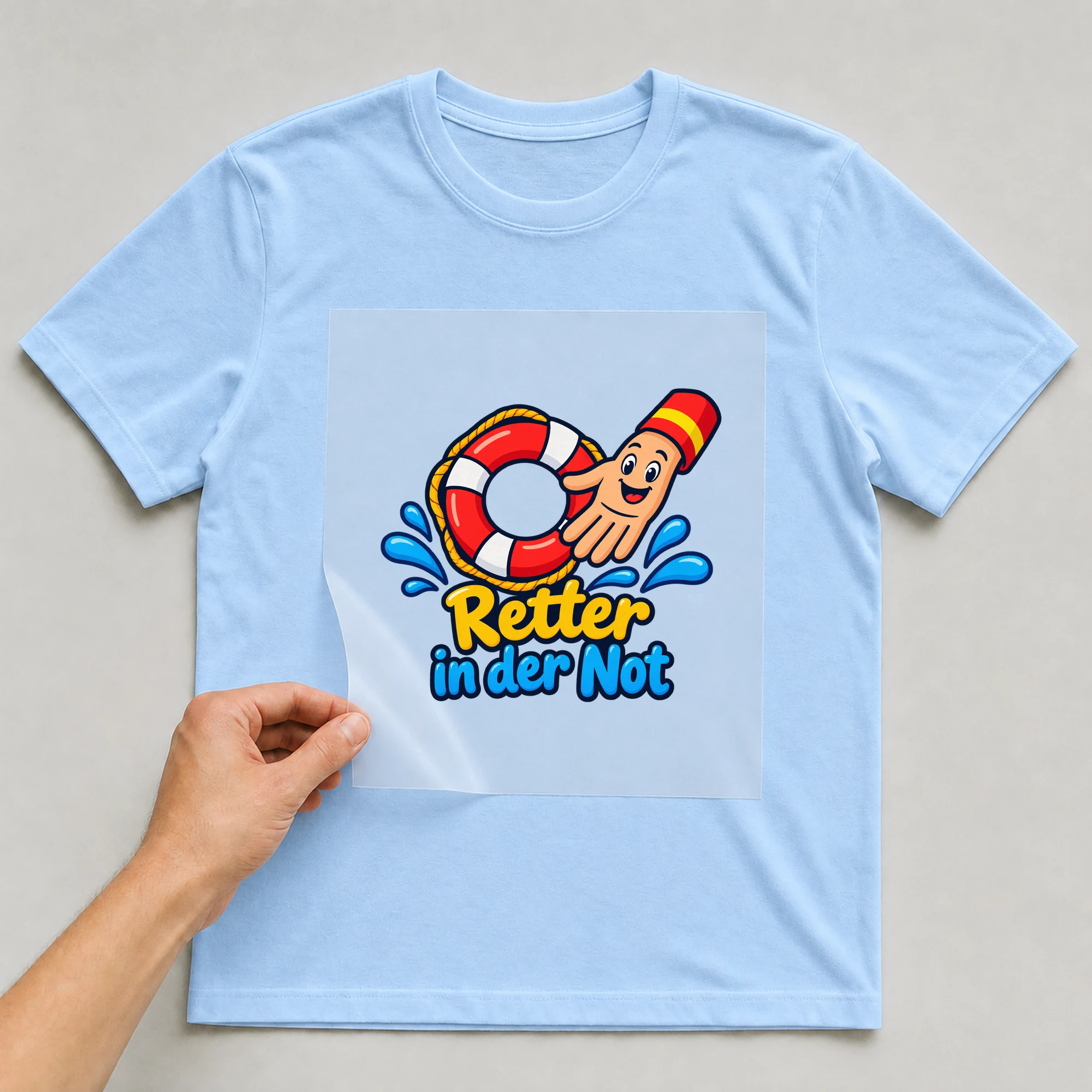 Bügelbild „Retter in der Not“ auf babyblauem T-Shirt, Folie wird aufgelegt