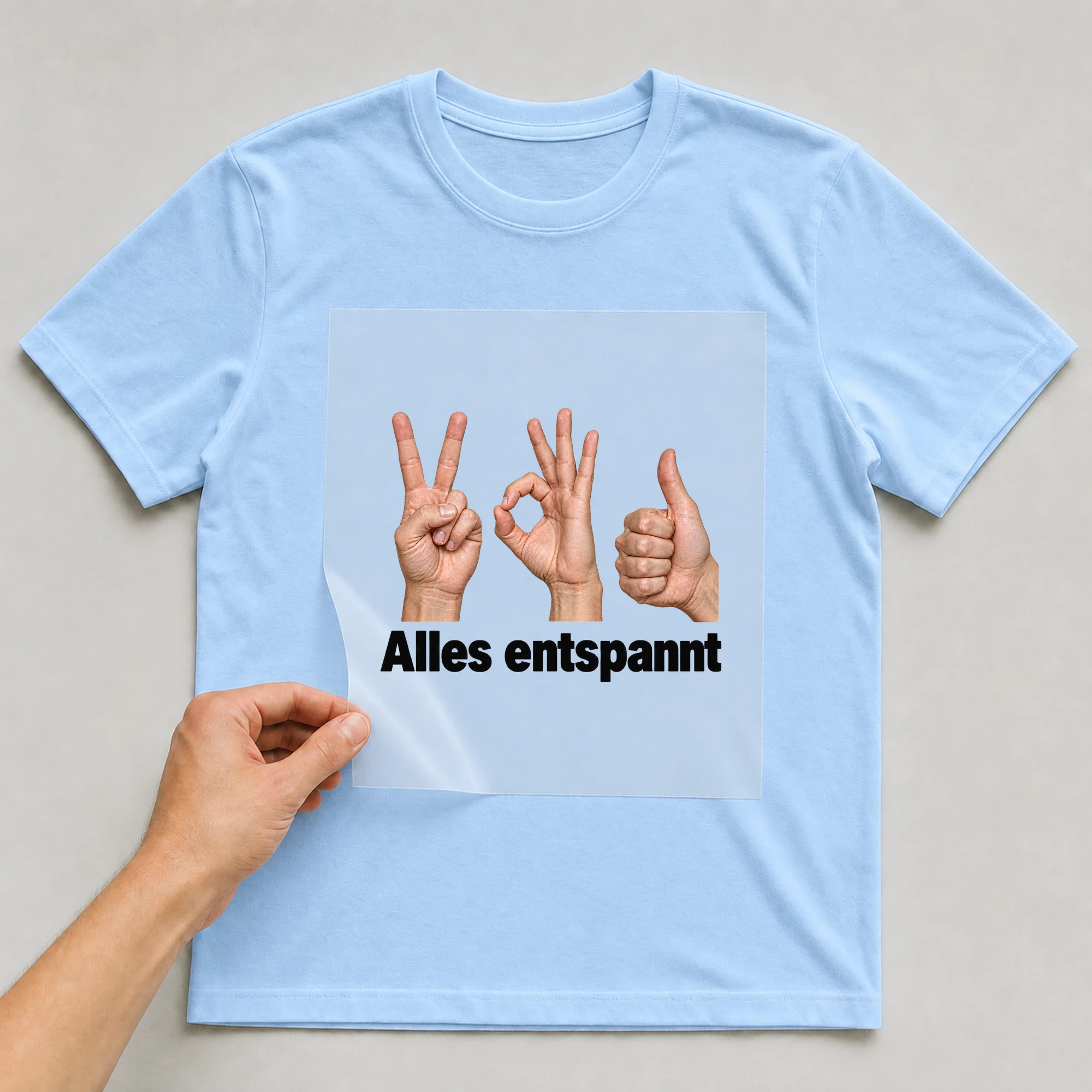 Bügelbild „Alles entspannt“ auf babyblauem T-Shirt, Folie wird aufgelegt