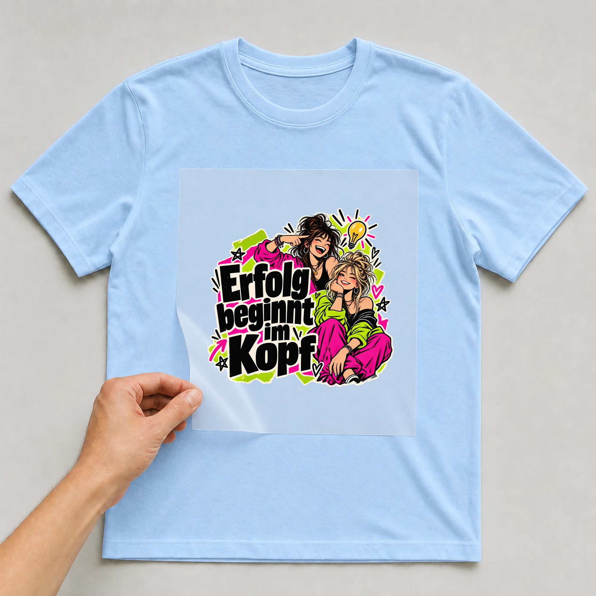Bügelbild „Erfolg beginnt im Kopf“ auf babyblauem T-Shirt, Folie wird aufgelegt