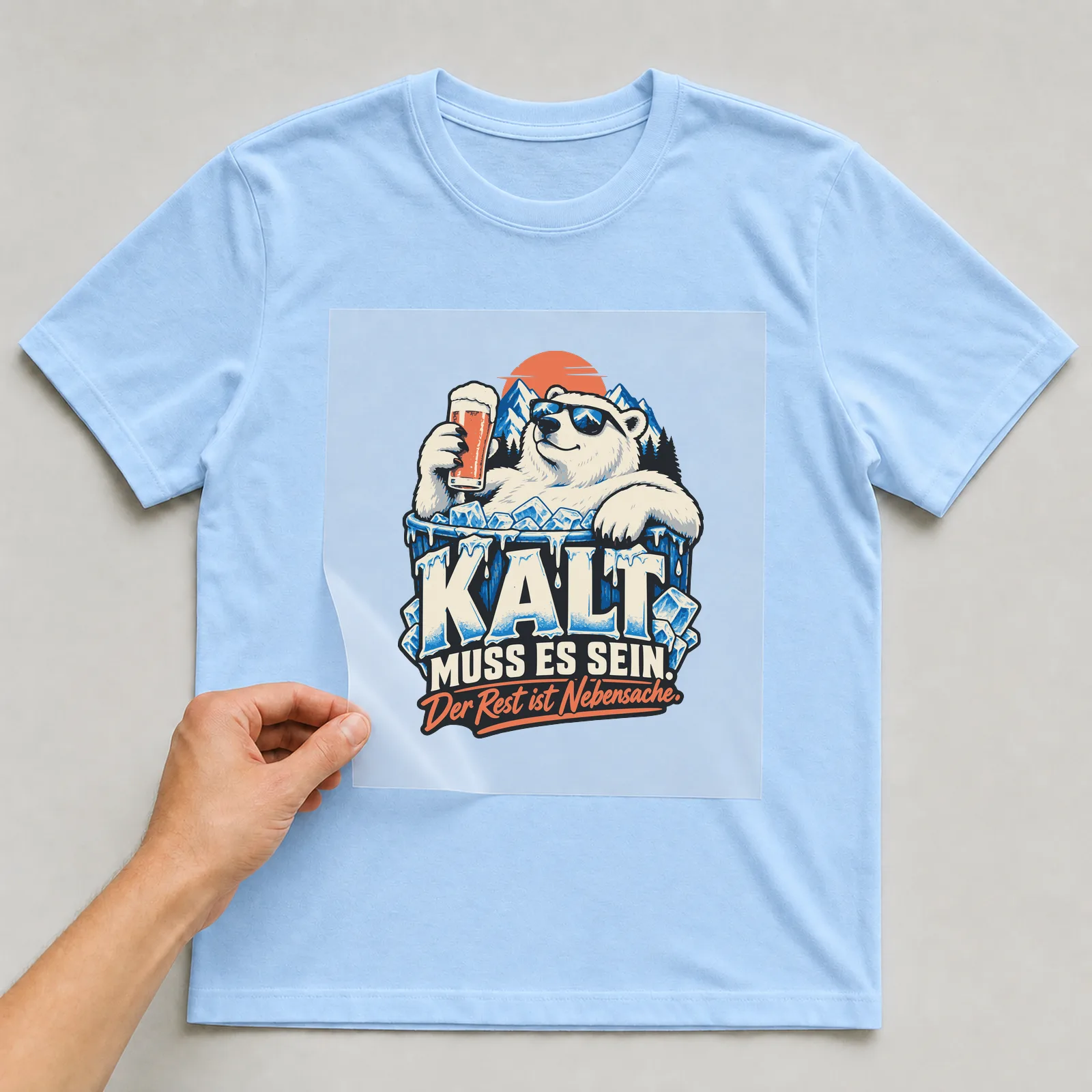 Bügelbild Kalt muss es sein. Der Rest ist Nebensache. auf hellblauem T-Shirt, Folie wird aufgelegt