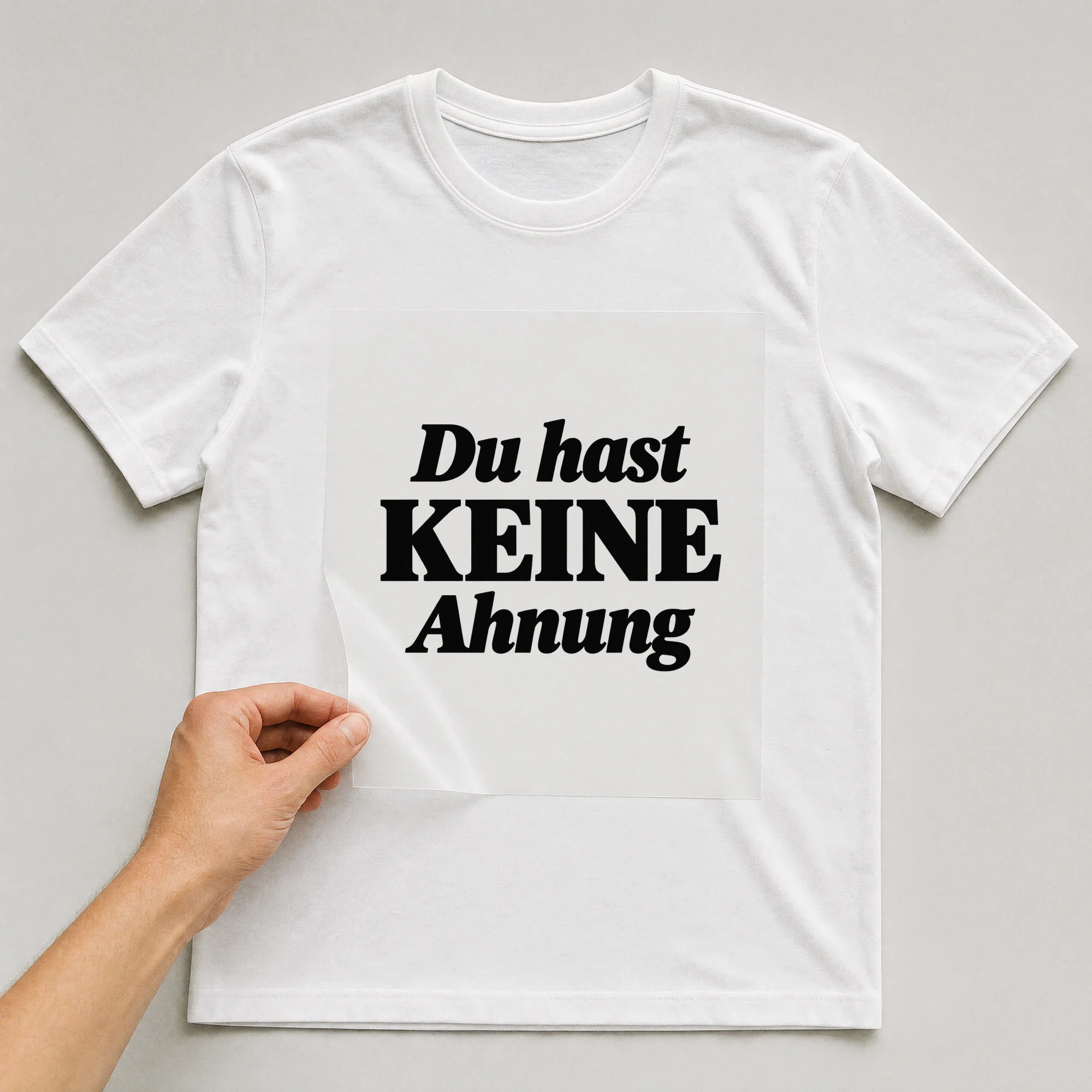 Bügelbild „Du hast keine Ahnung“ auf weißem T-Shirt, Folie wird aufgelegt