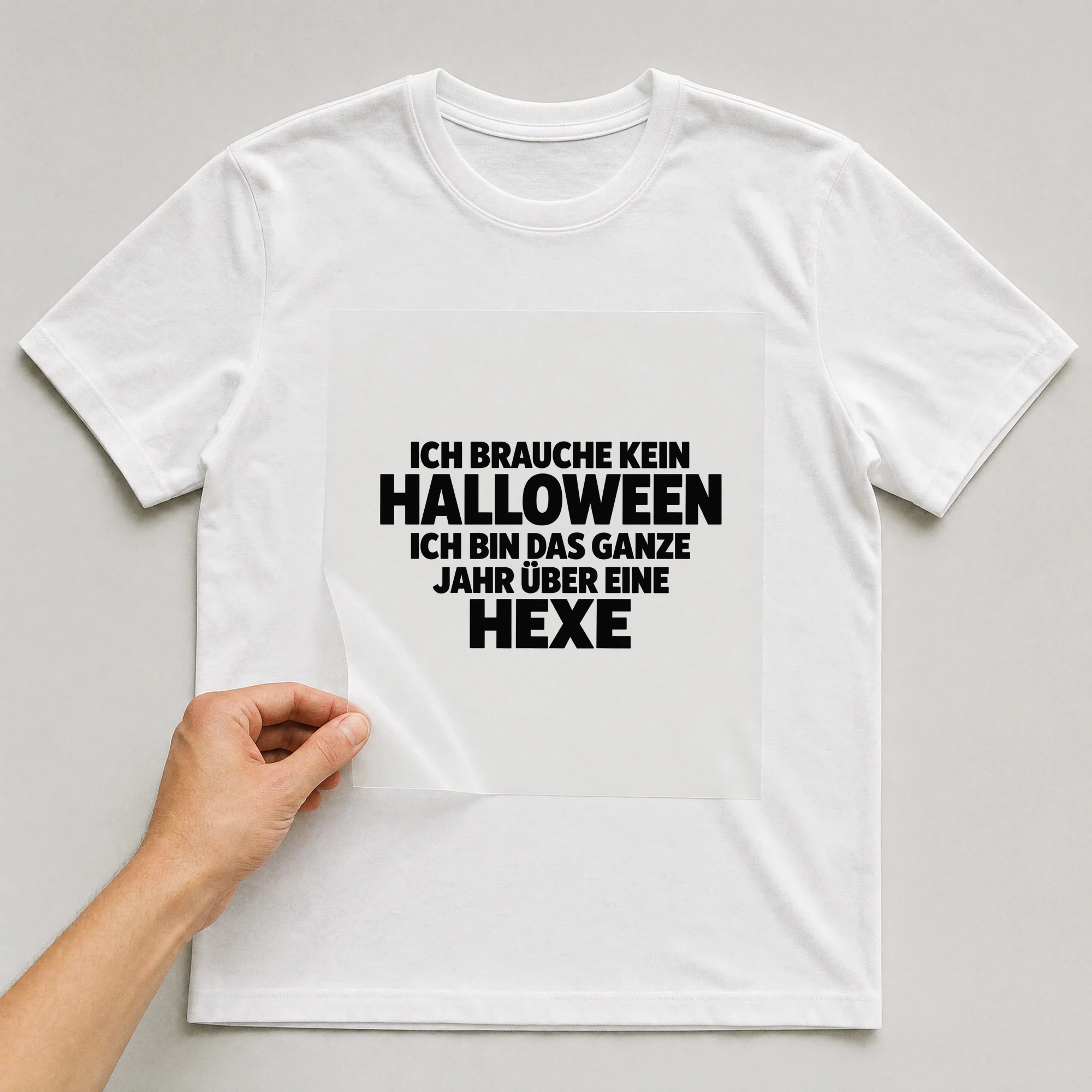 Bügelbild „Ich brauche kein Halloween ich bin das ganze Jahr über eine Hexe“ auf weißem T-Shirt, Folie wird aufgelegt