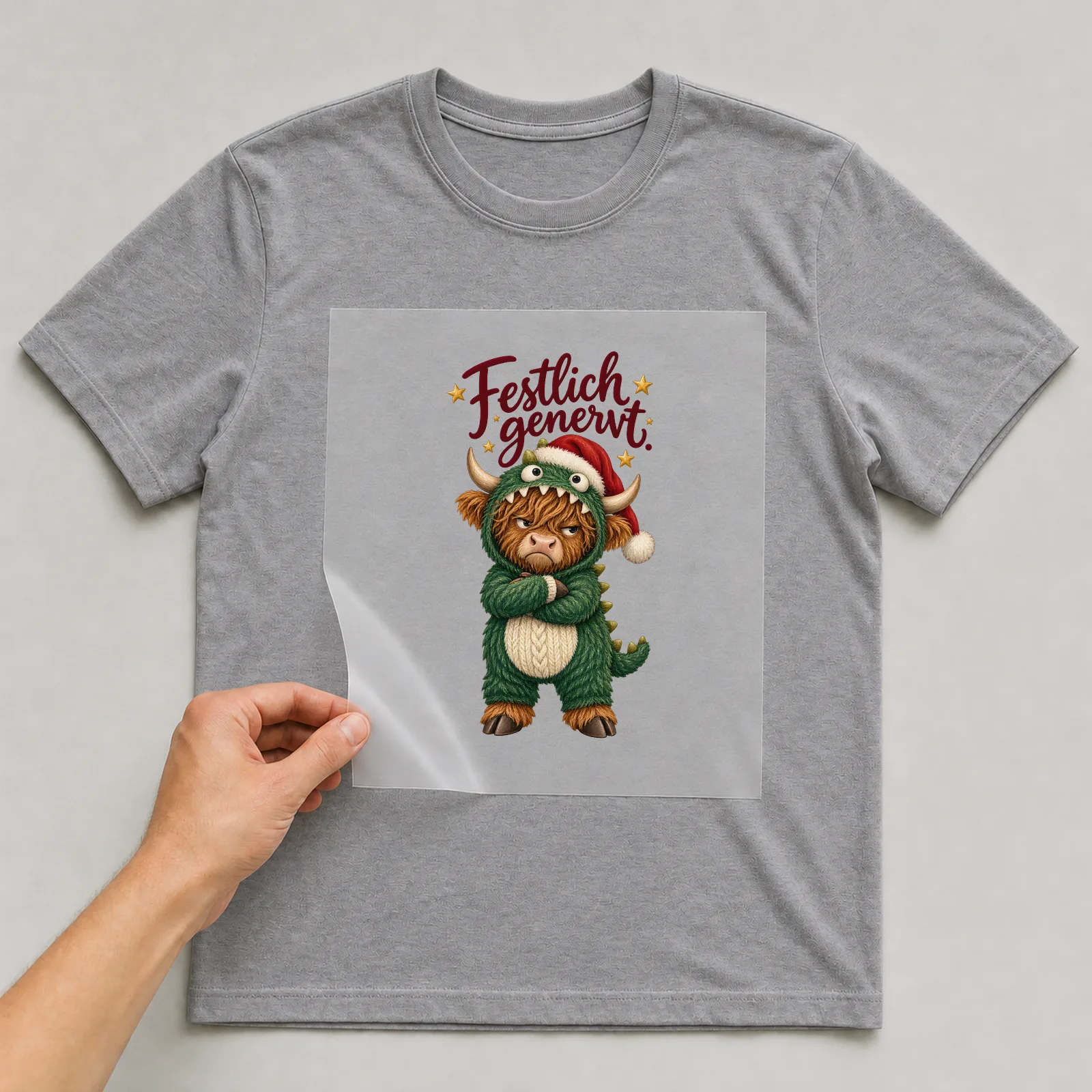 Bügelbild Festlich genervt. auf grauem T-Shirt, Folie wird aufgelegt