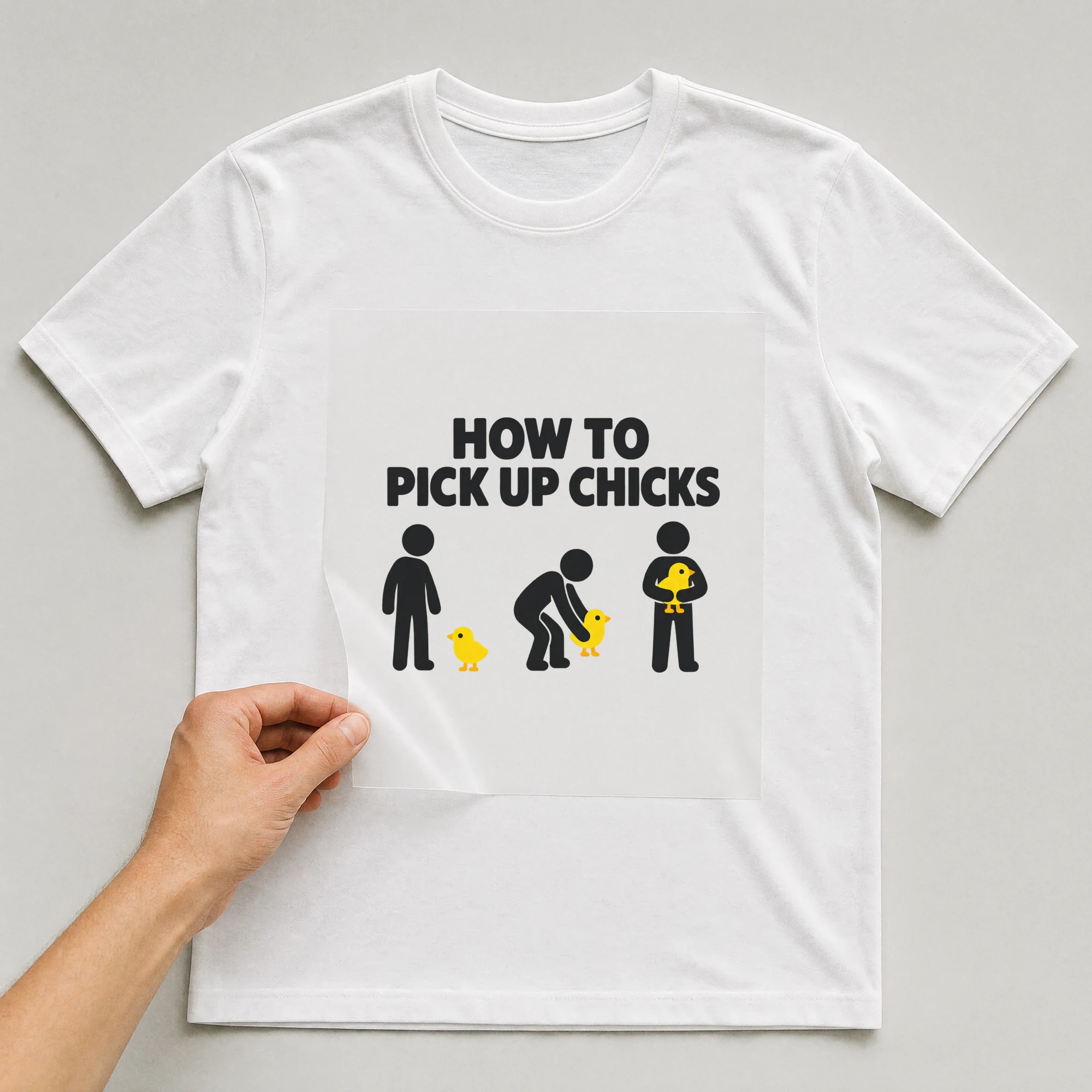 Bügelbild „HOW TO PICK UP CHICKS“ auf weißem T-Shirt, Folie wird aufgelegt