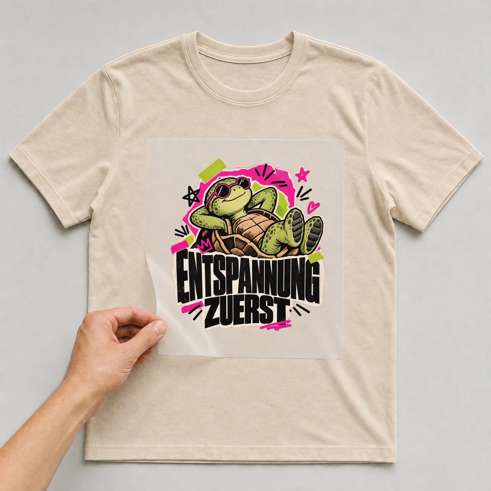 Bügelbild „Entspannung zuerst“ auf beigem T-Shirt, Folie wird aufgelegt