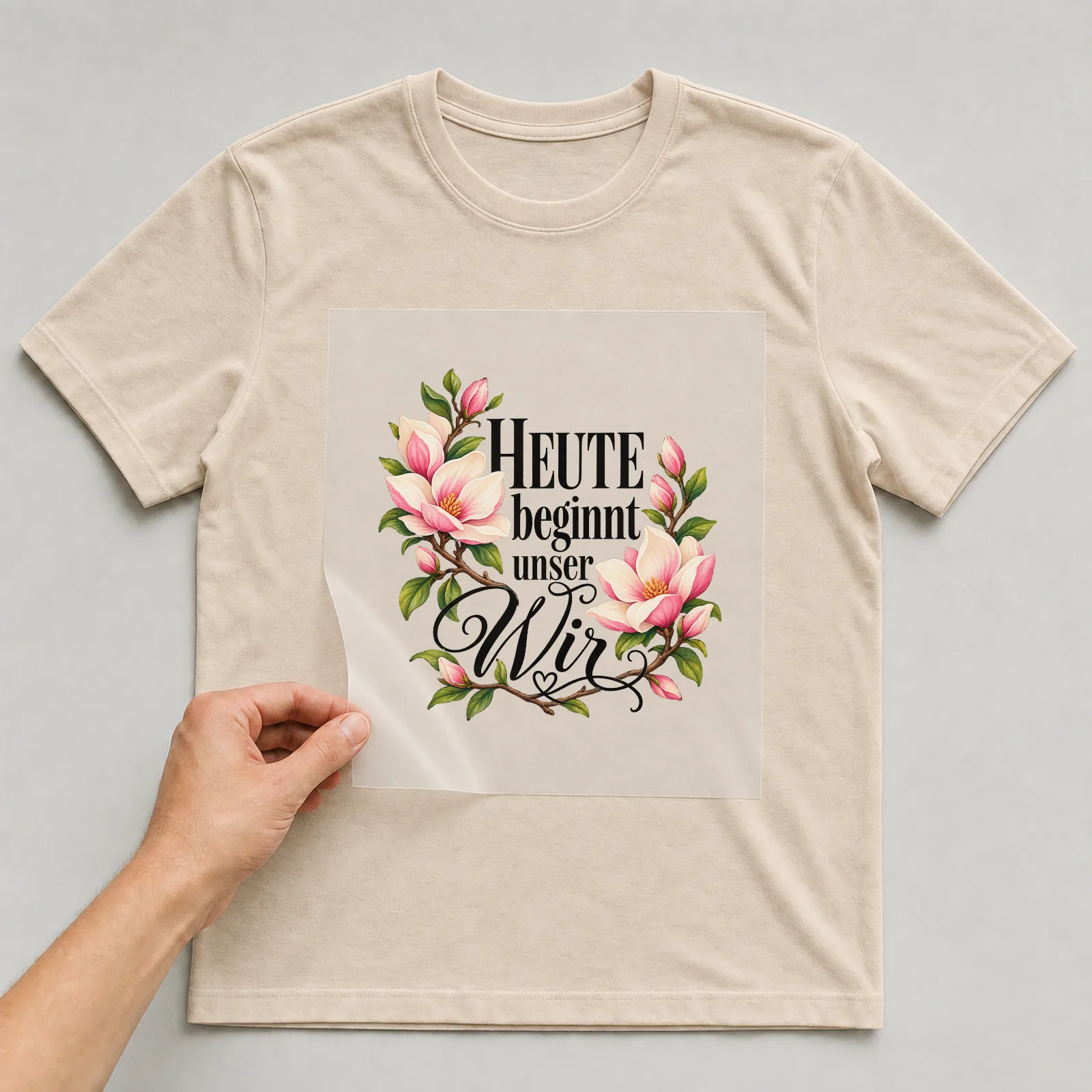 Bügelbild „Heute beginnt unser Wir“ (deckendem Aquarell) auf beigem T-Shirt, Folie wird aufgelegt