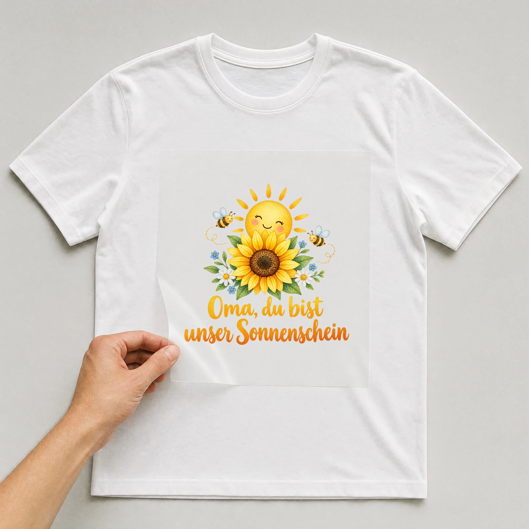 Bügelbild „Oma, du bist unser Sonnenschein“ auf weißem T-Shirt, Folie wird aufgelegt