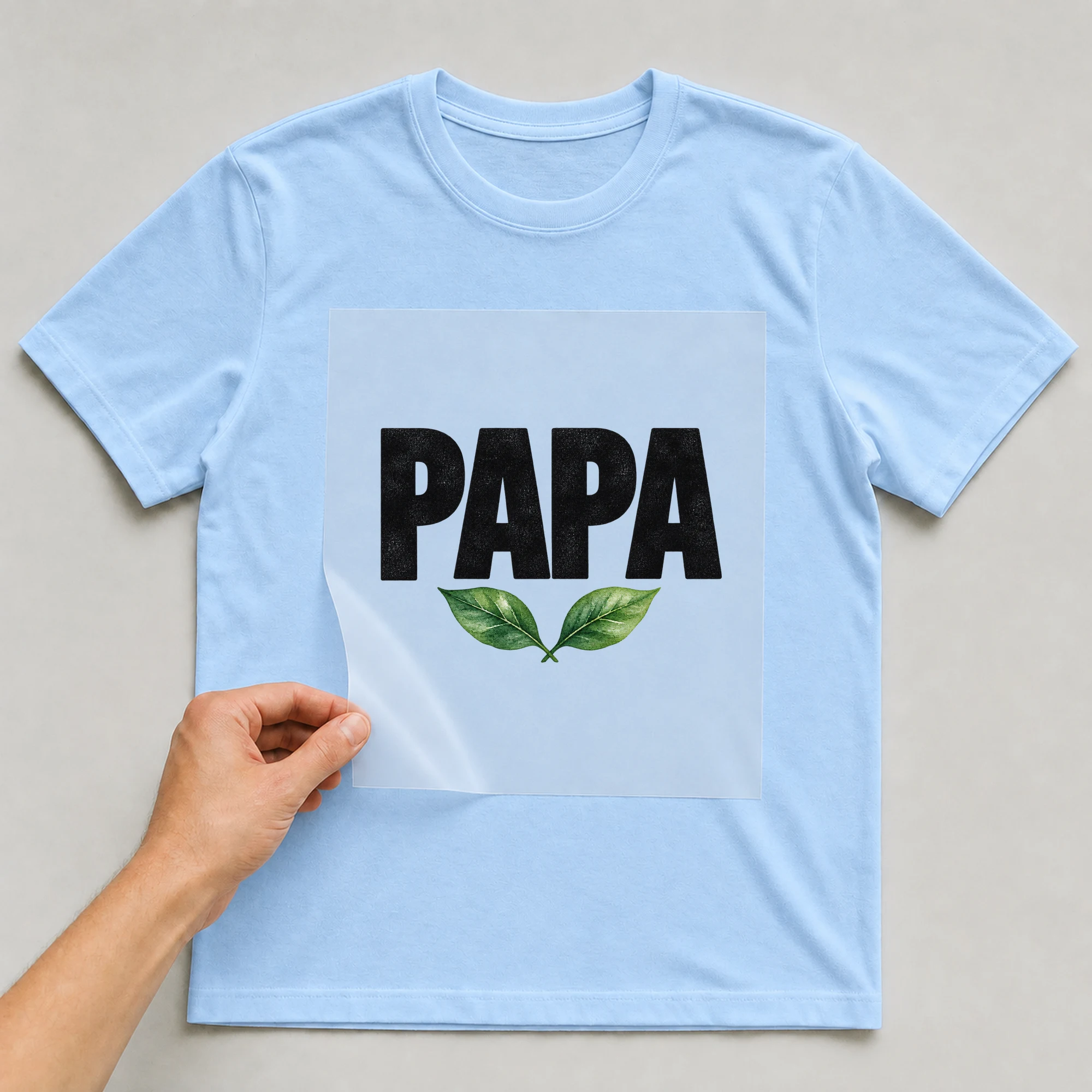 Bügelbild „Papa“ auf babyblauem T-Shirt, Folie wird aufgelegt