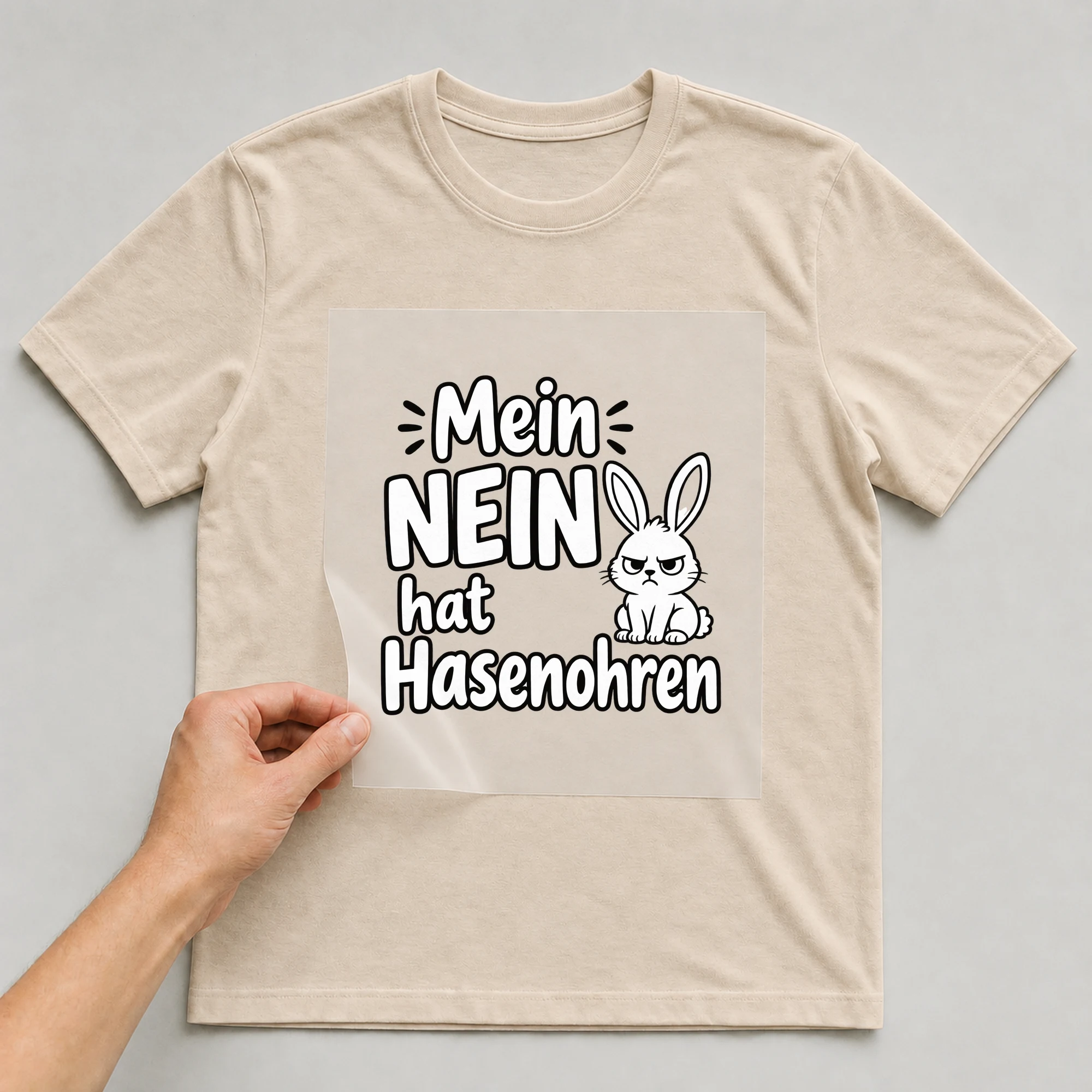 Bügelbild „Mein Nein hat Hasenohren“ auf beigem T-Shirt, Folie wird aufgelegt