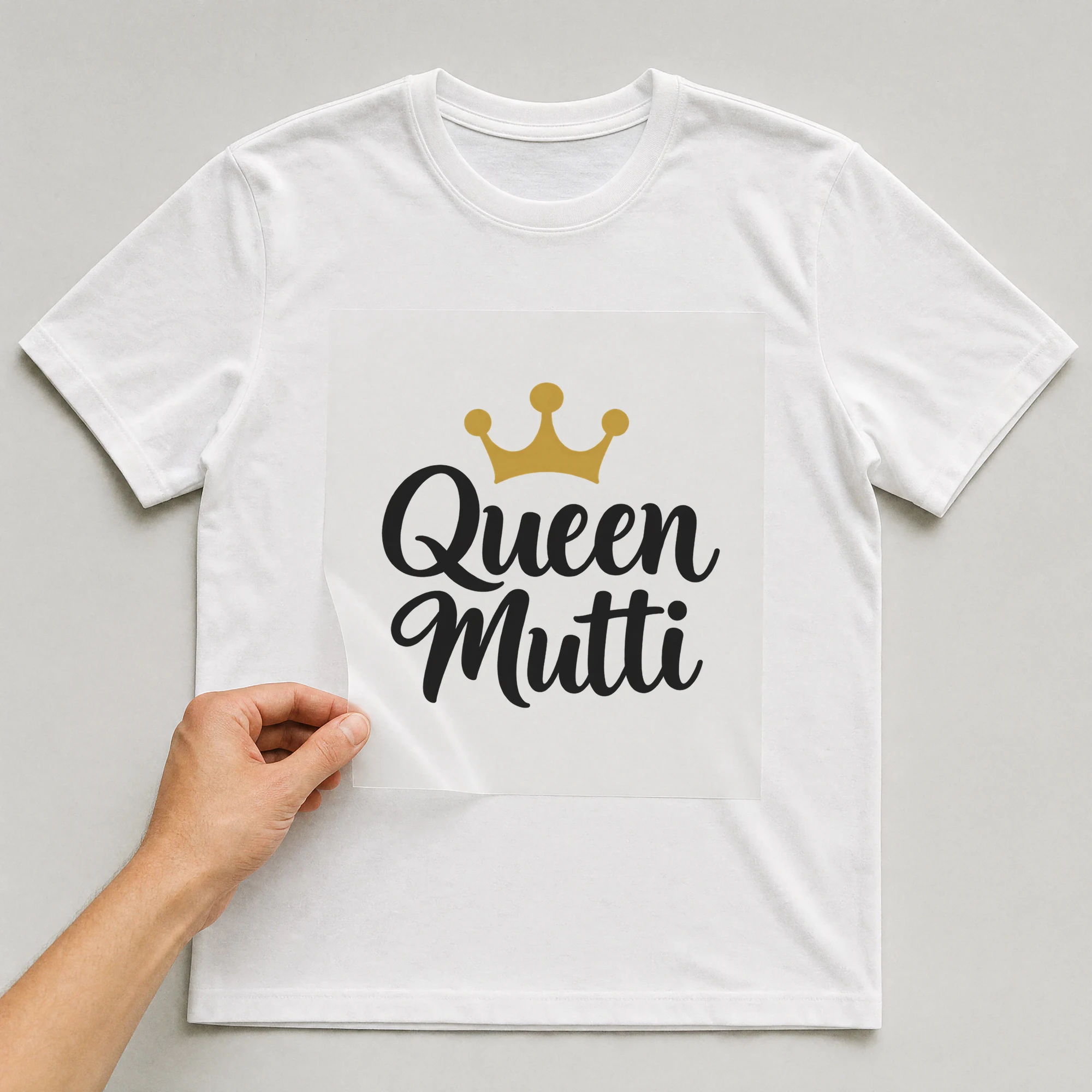 Bügelbild „Queen Mutti“ auf weißem T-Shirt, Folie wird aufgelegt
