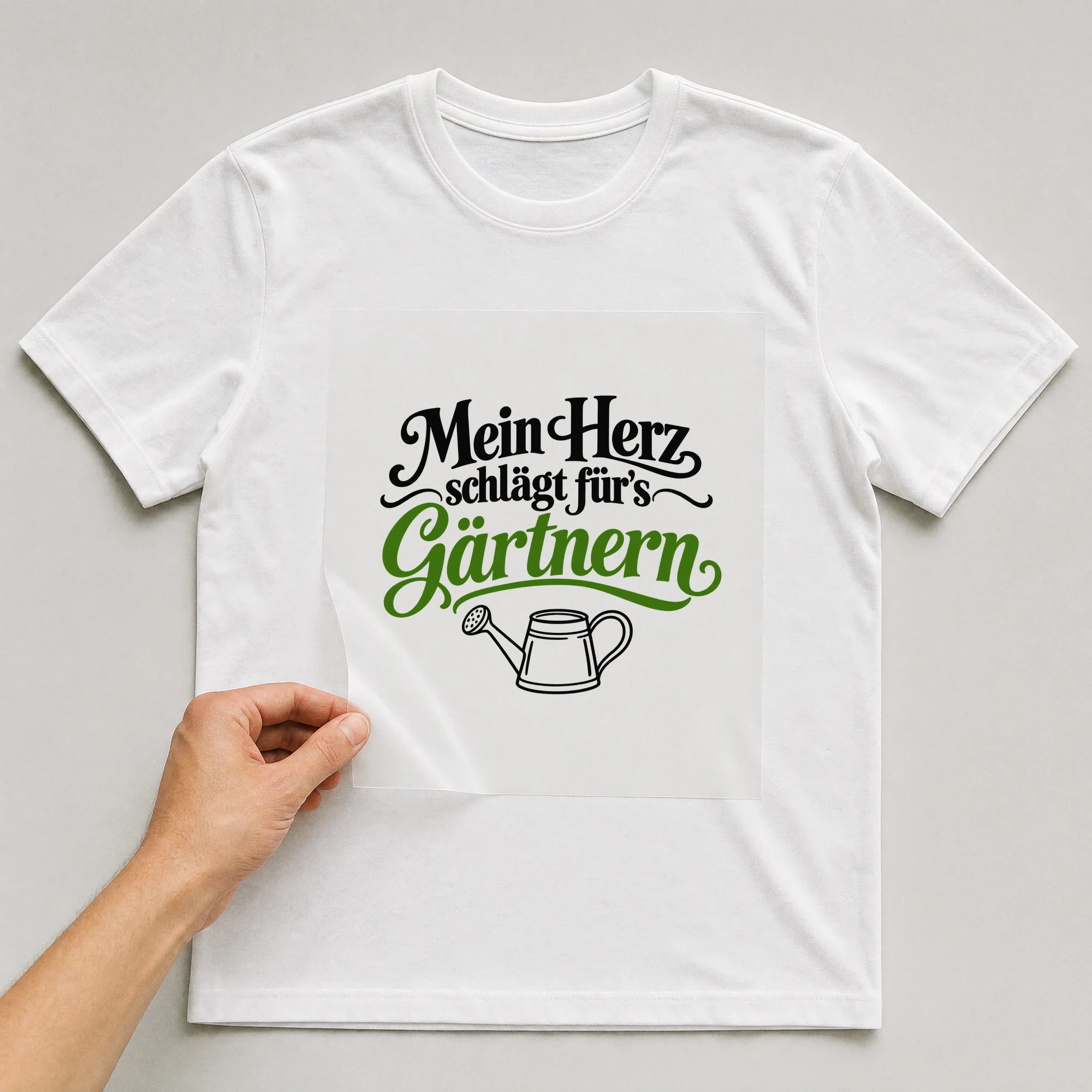 Bügelbild „Mein Herz schlägt für's Gärtnern“ auf weißem T-Shirt, Folie wird aufgelegt