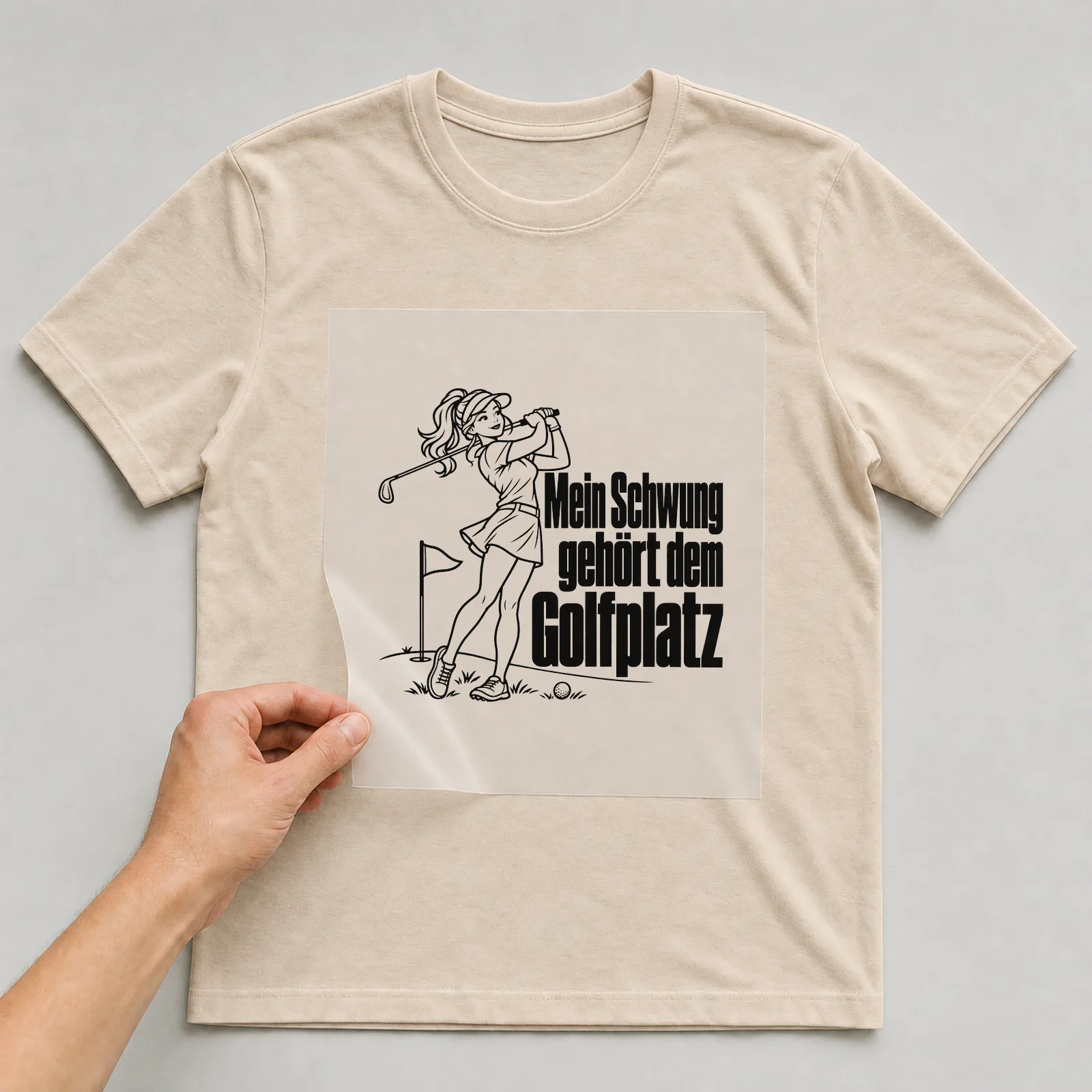 Bügelbild „Mein Schwung gehört dem Golfplatz“ auf beigem T-Shirt, Folie wird aufgelegt