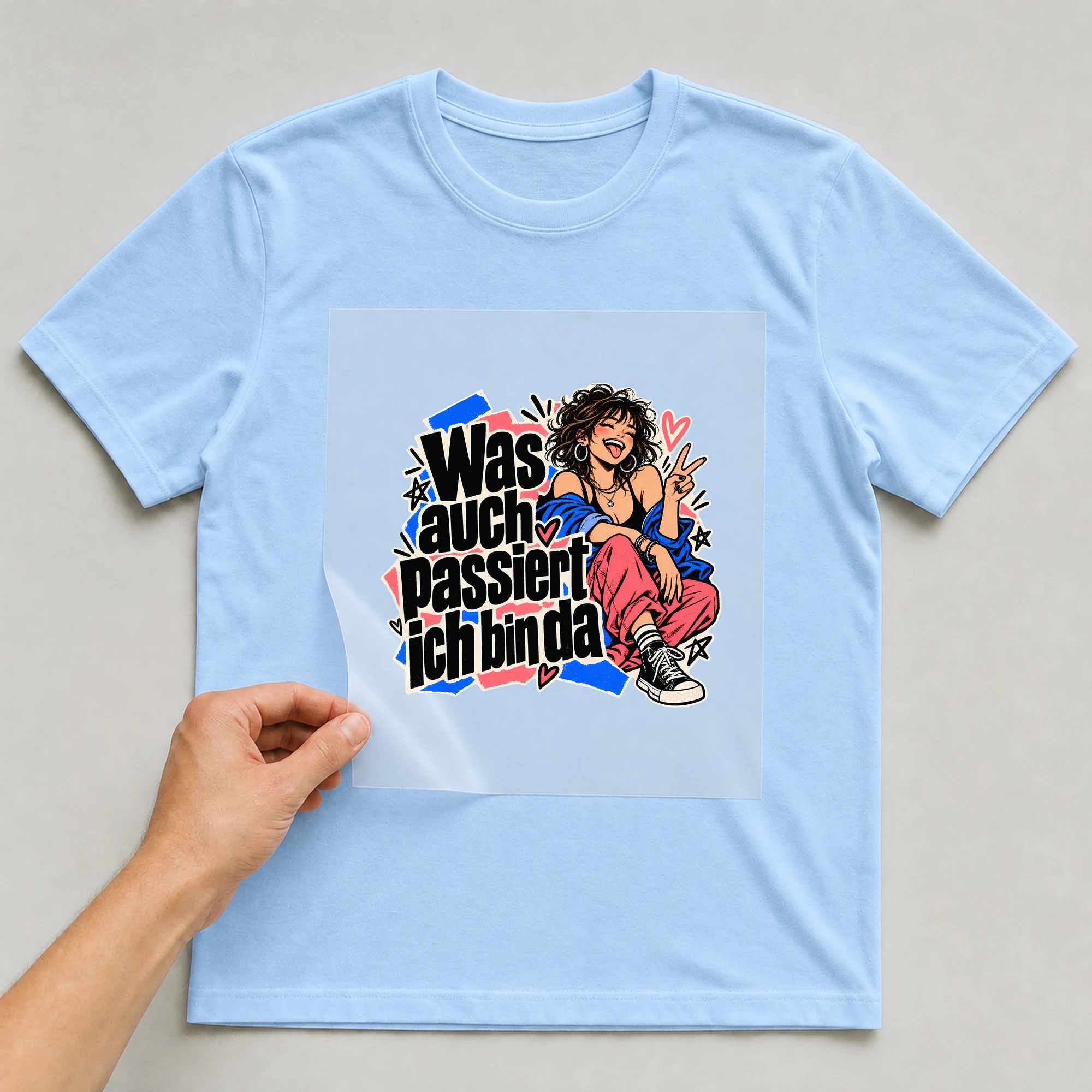 Bügelbild „Was auch passiert ich bin da“ auf babyblauem T-Shirt, Folie wird aufgelegt