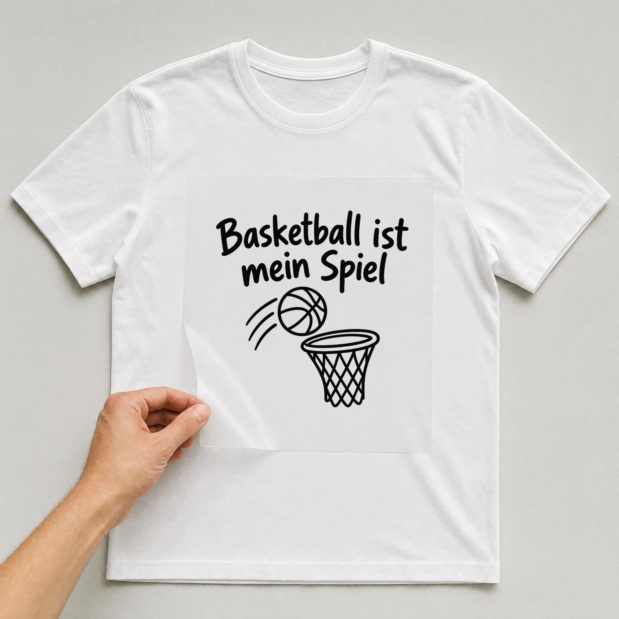 Bügelbild „Basketball ist mein Spiel“ auf weißem T-Shirt, Folie wird aufgelegt