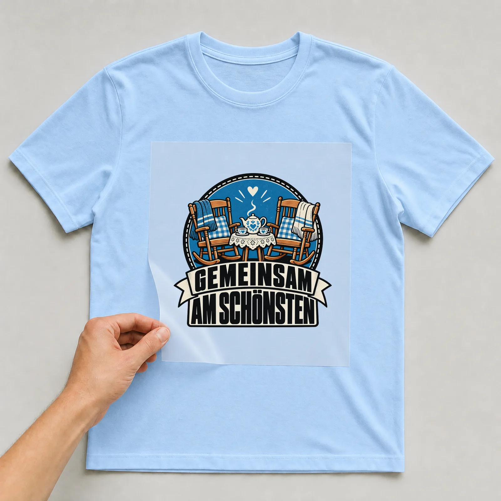 Bügelbild „Gemeinsam am schönsten“ auf hellblauem T-Shirt, Folie wird aufgelegt