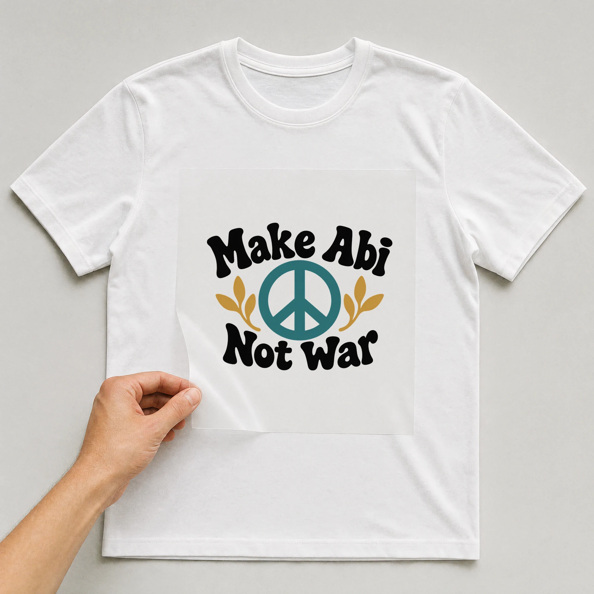 Bügelbild „Make Abi Not War“ auf weißem T-Shirt, Folie wird aufgelegt
