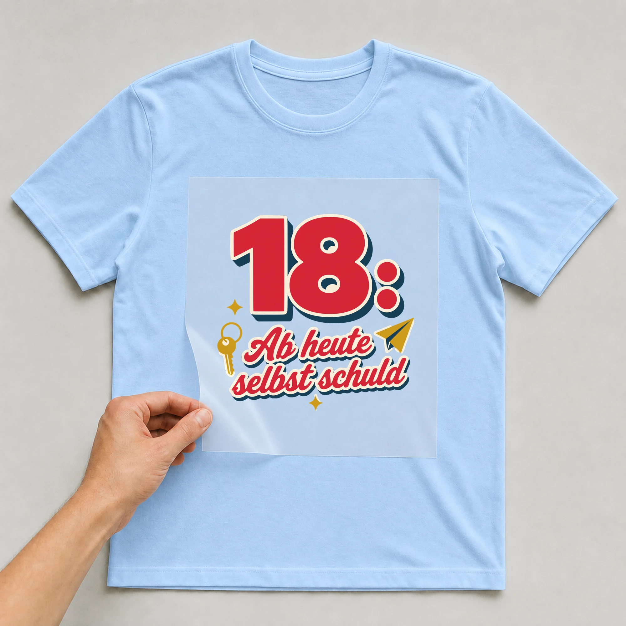Bügelbild 18: Ab heute selbst schuld auf hellblauem T-Shirt, Folie wird aufgelegt