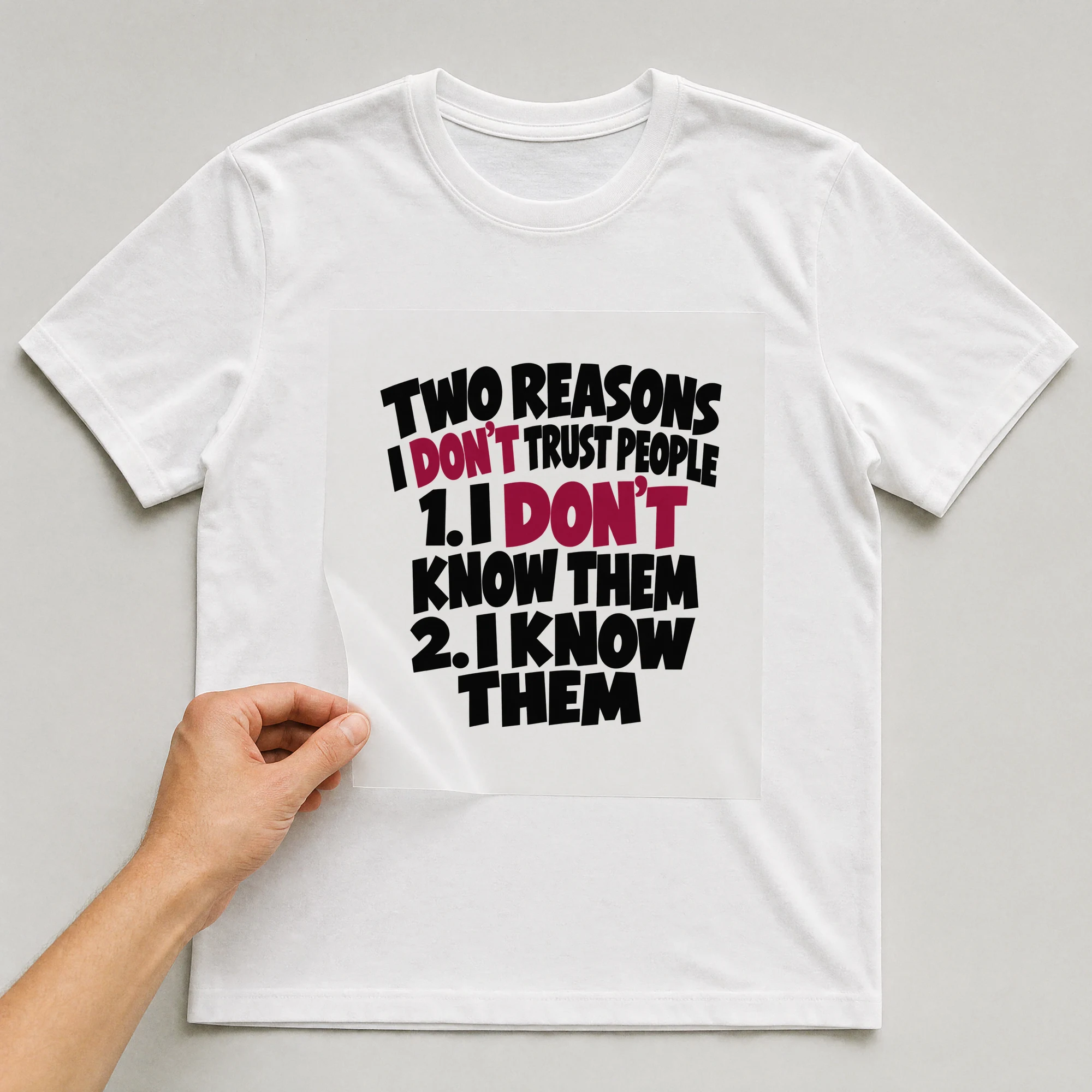 Bügelbild „Two Reasons I Don't Trust People 1. I Don't Know Them 2. I Know Them“ auf weißem T-Shirt, Folie wird aufgelegt