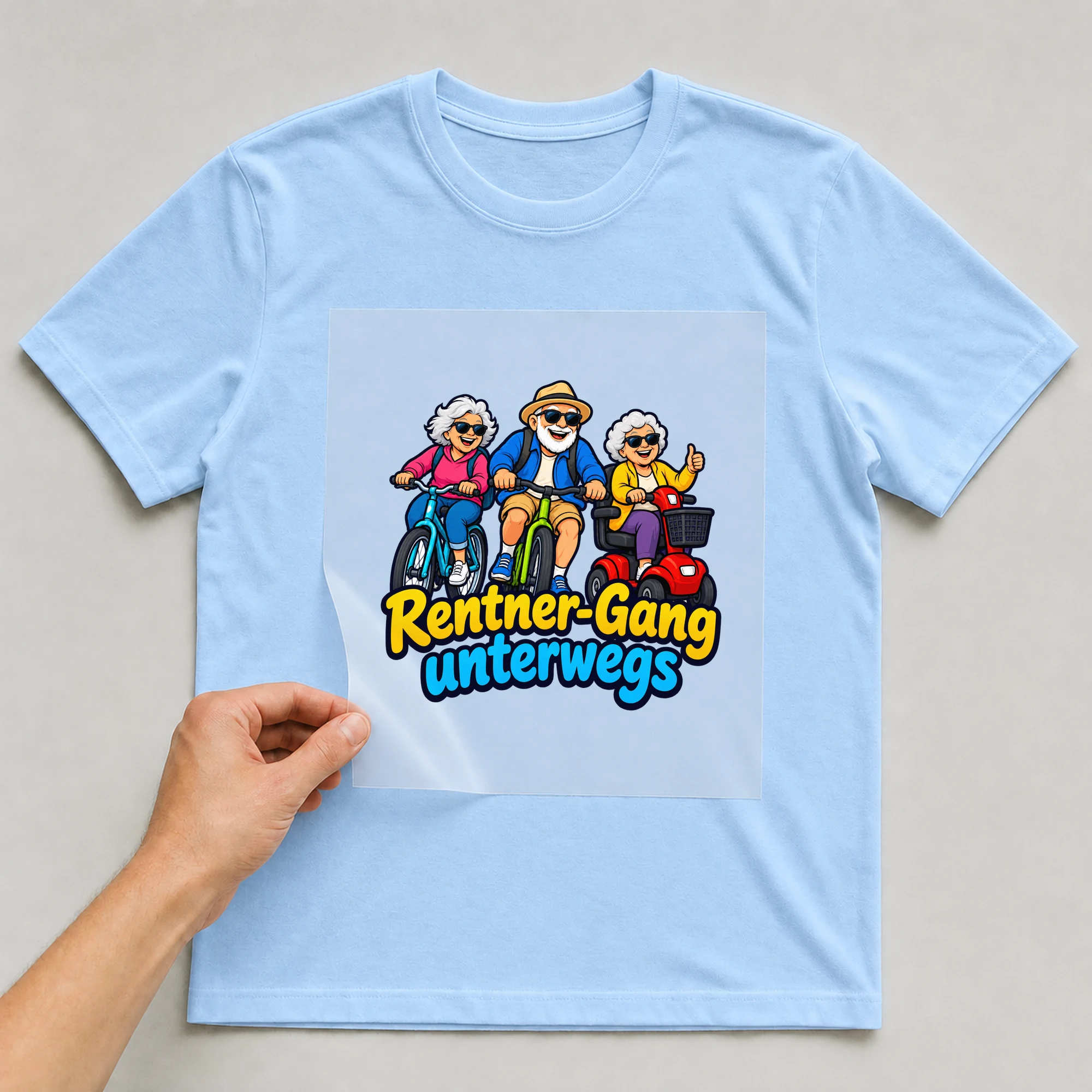 Bügelbild „Rentner-Gang unterwegs“ auf babyblauem T-Shirt, Folie wird aufgelegt