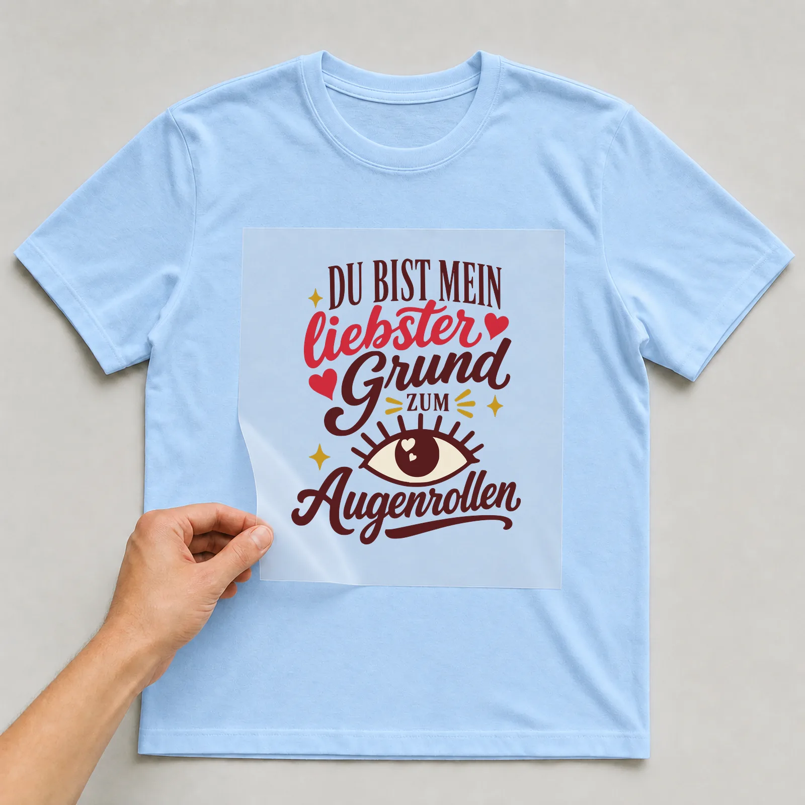 Bügelbild Du bist mein liebster Grund zum Augenrollen auf hellblauem T-Shirt, Folie wird aufgelegt