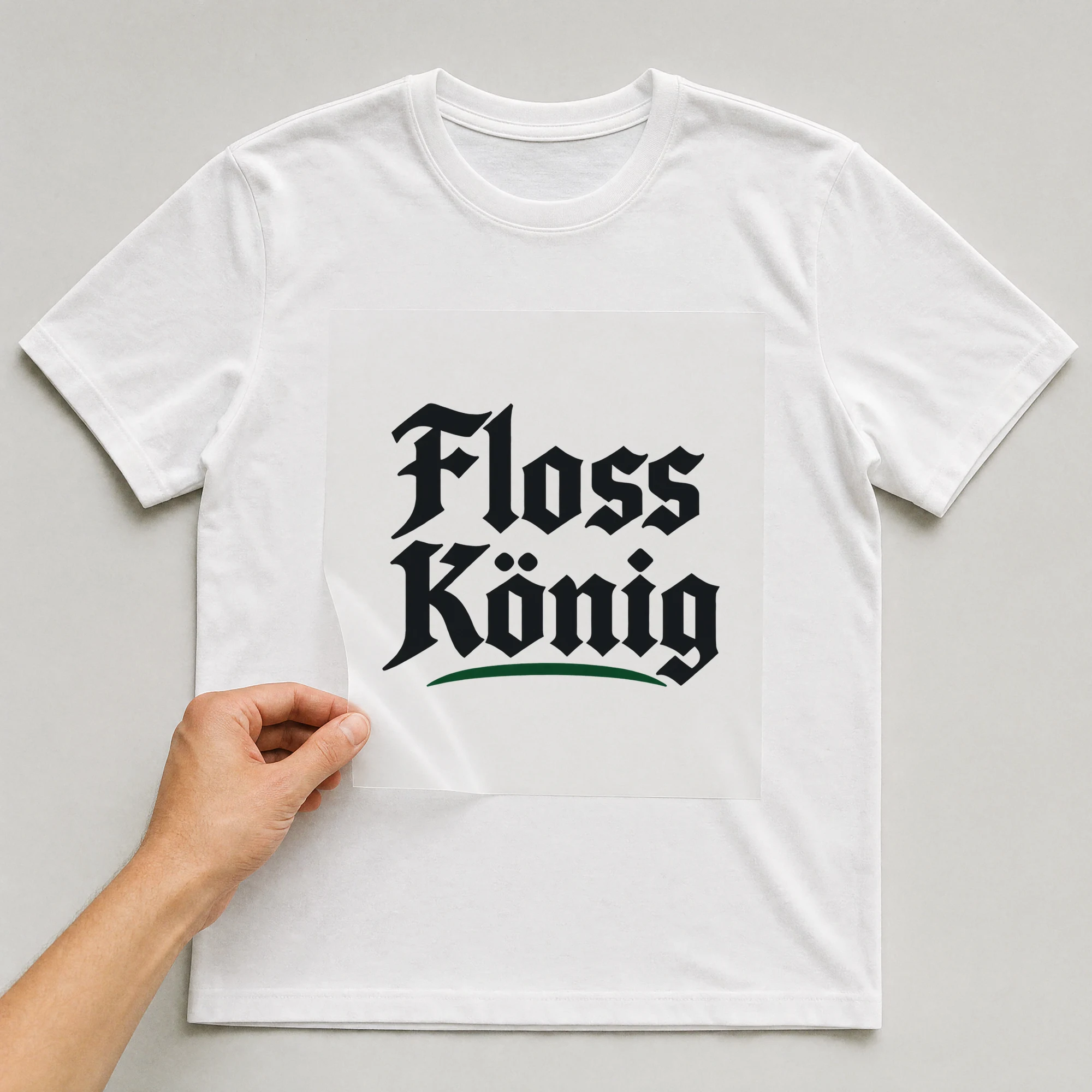 Bügelbild „Floss König“ auf weißem T-Shirt, Folie wird aufgelegt