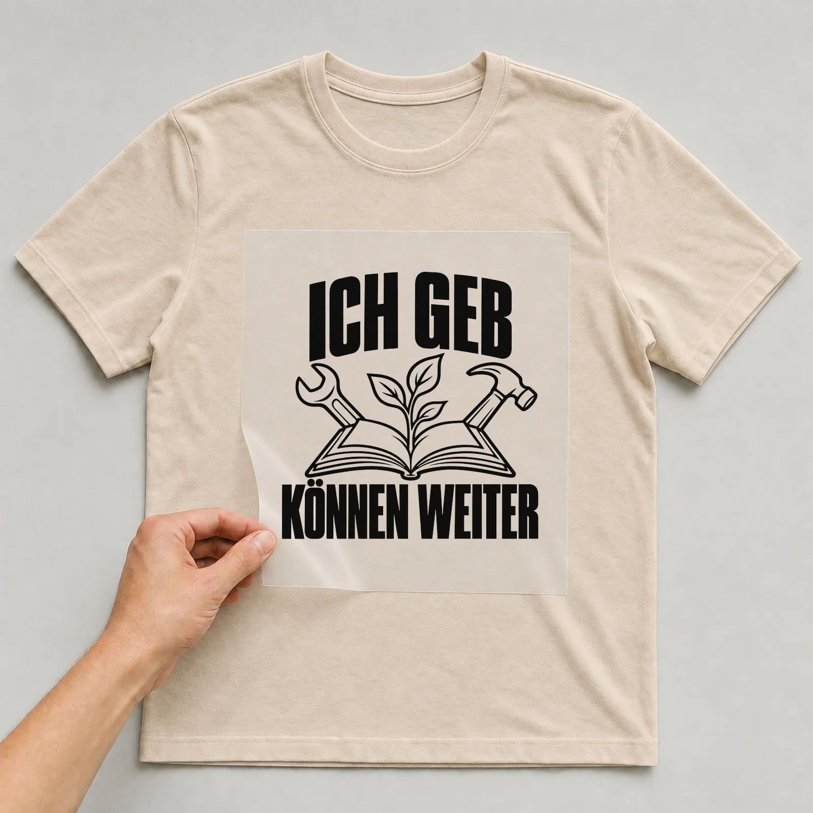 Bügelbild „Ich geb können weiter“ auf beigem T-Shirt, Folie wird aufgelegt