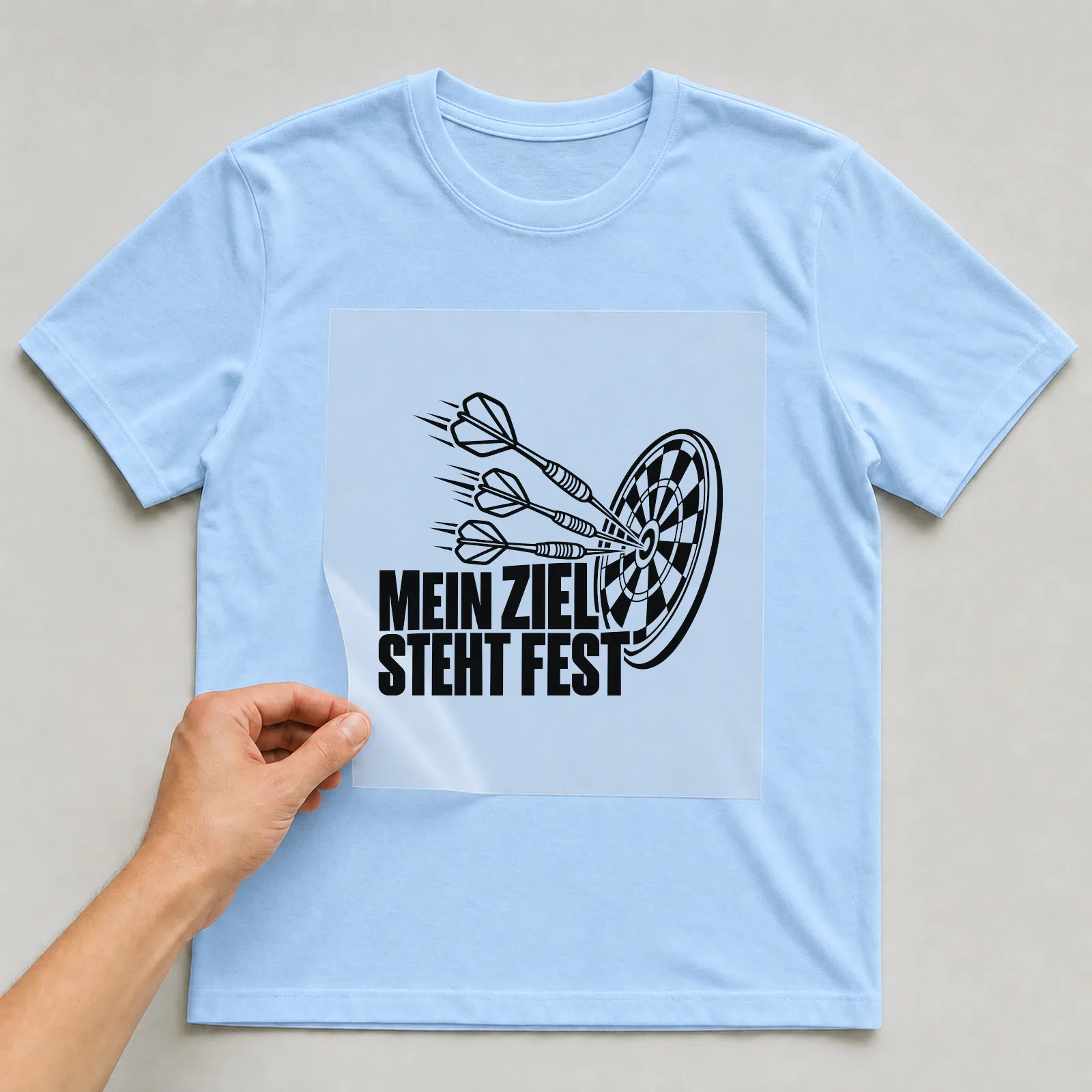Bügelbild „Mein Ziel steht fest“ auf hellblauem T-Shirt, Folie wird aufgelegt