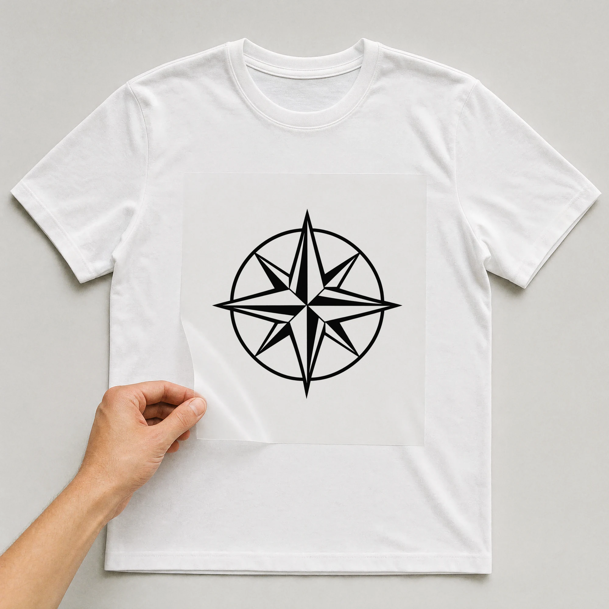 Bügelbild „Sailing Compass“ auf weißem T-Shirt, Folie wird aufgelegt