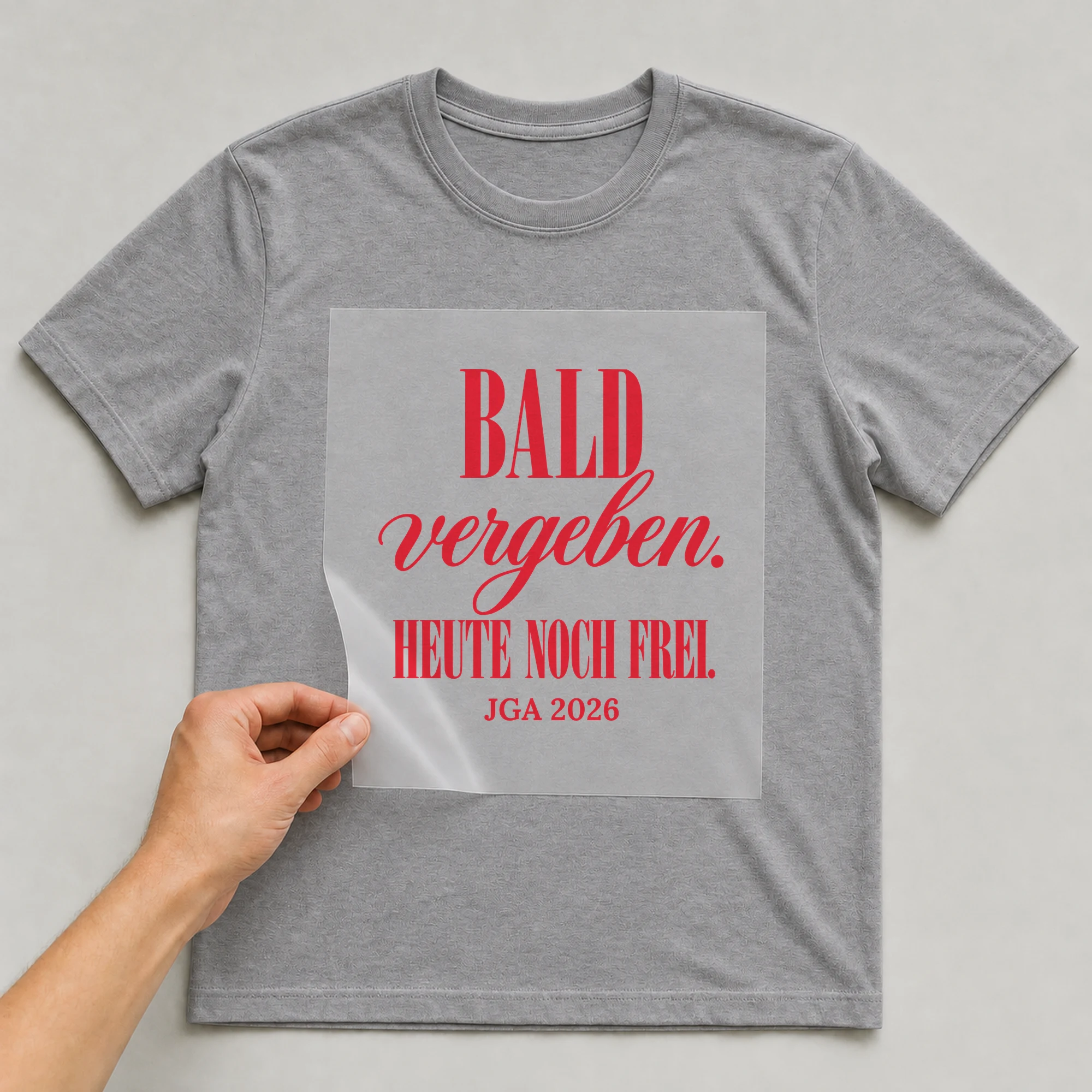 Bügelbild Bald vergeben. Heute noch frei. auf grauem T-Shirt, Folie wird aufgelegt