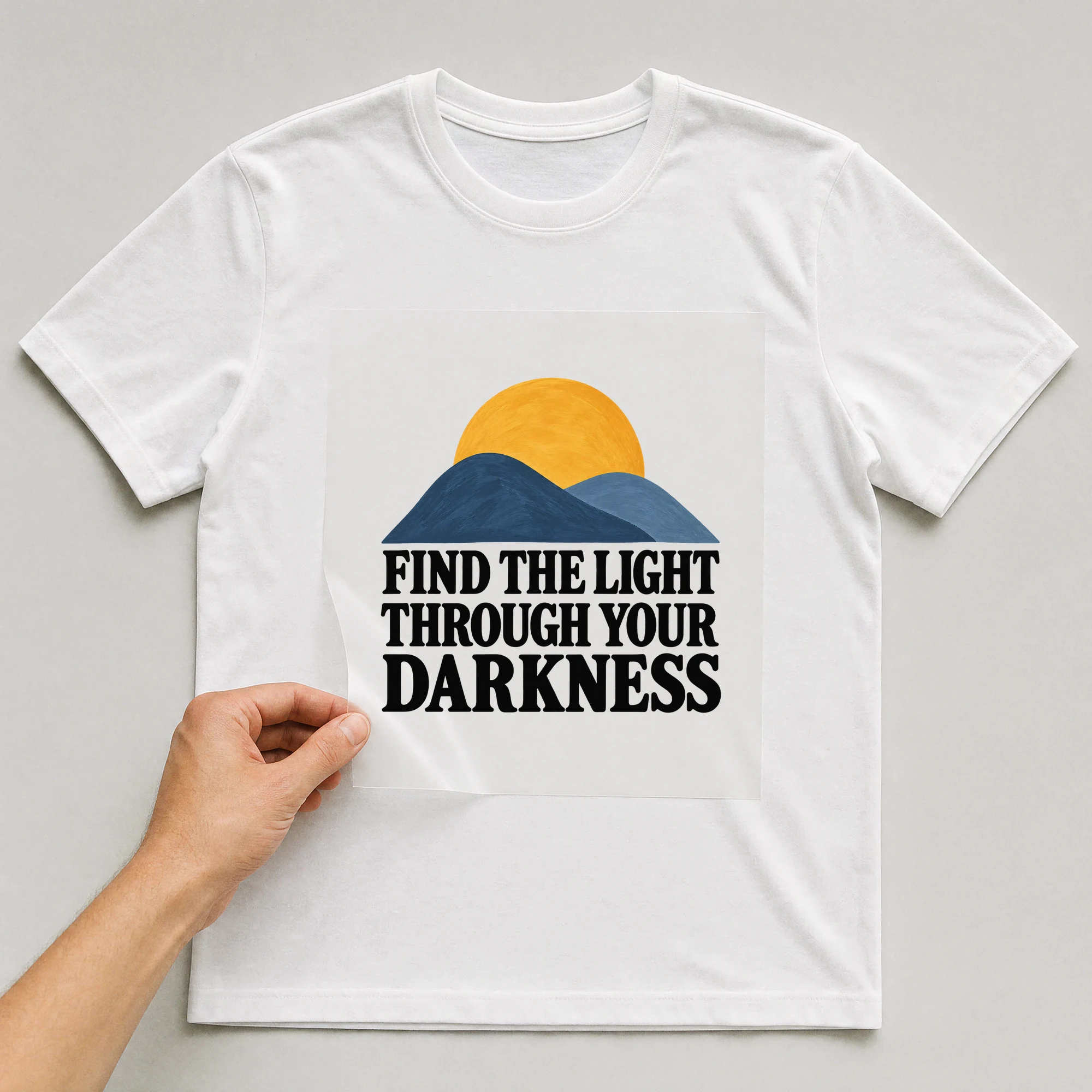 Bügelbild „Find The Light Through Your Darkness“ auf weißem T-Shirt, Folie wird aufgelegt