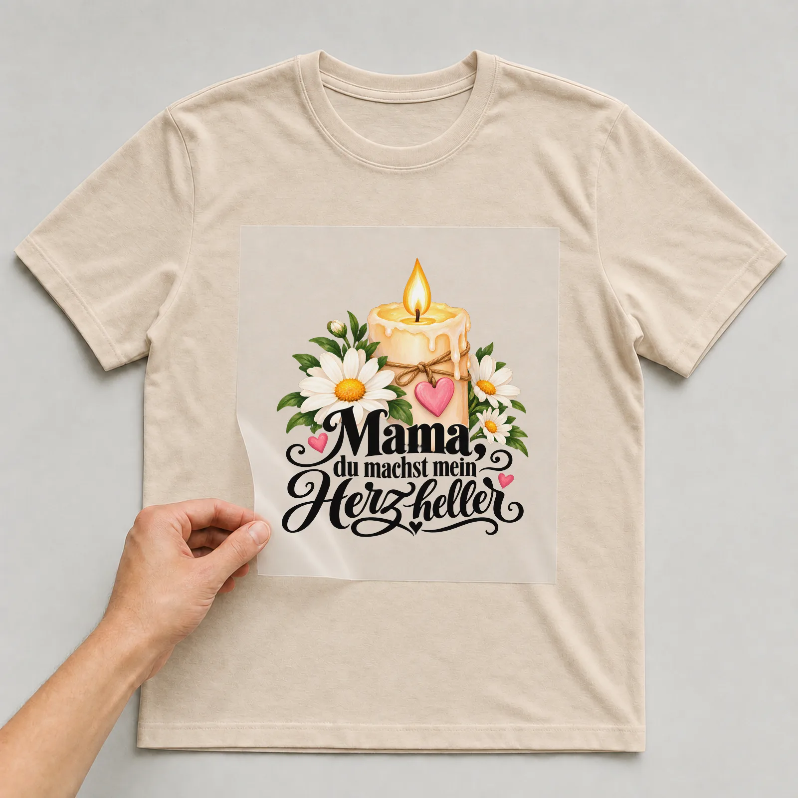 Bügelbild „Mama, du machst mein Herz heller“ auf beigem T-Shirt, Folie wird aufgelegt