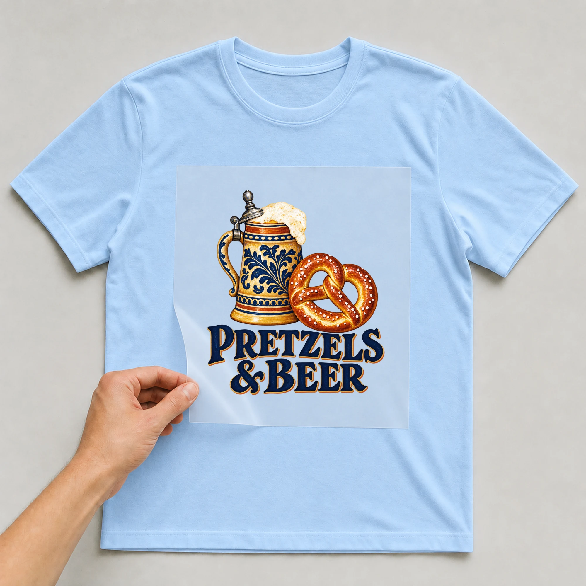 Bügelbild „Pretzels & Beer“ auf babyblauem T-Shirt, Folie wird aufgelegt