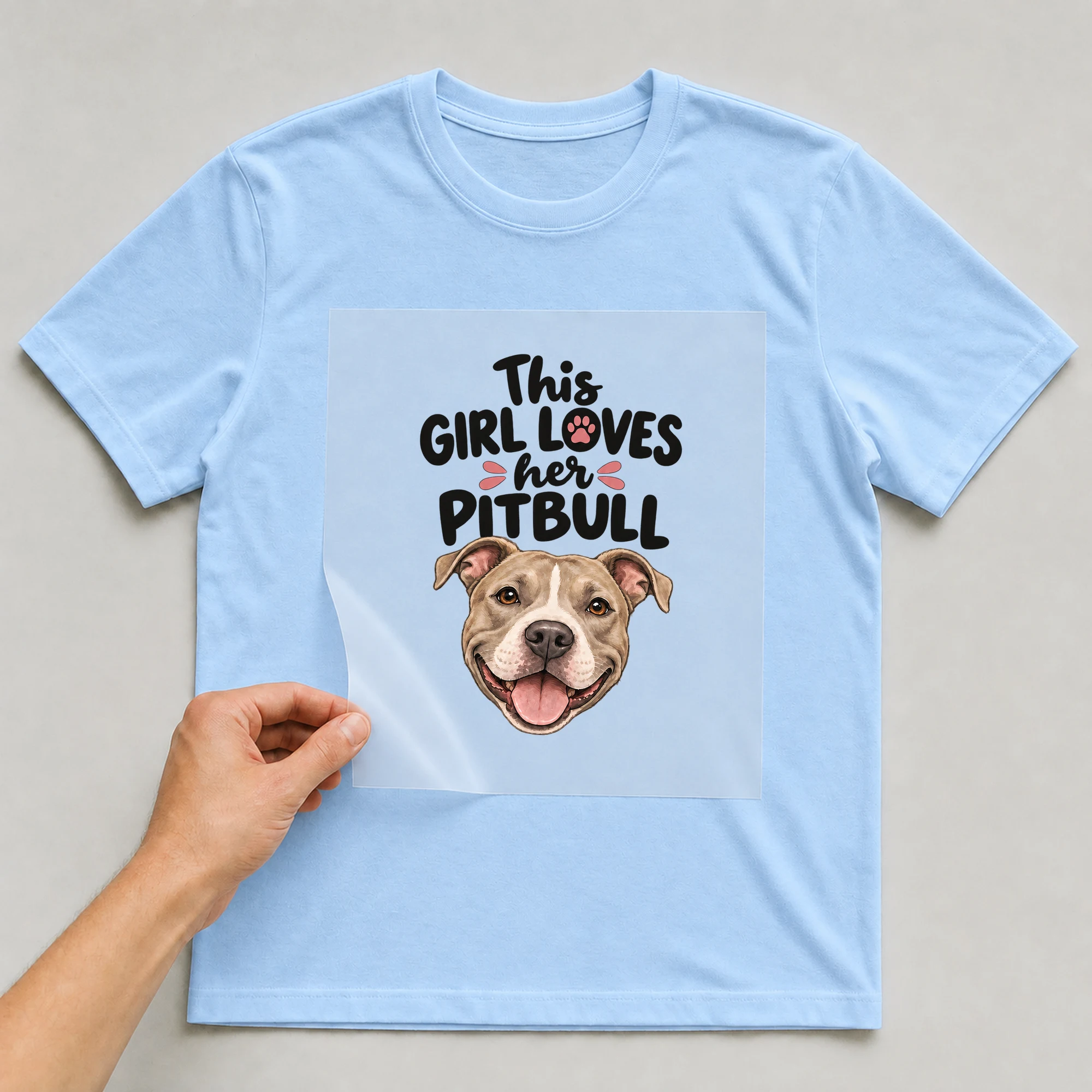Bügelbild „This Girl Loves Her Pitbull“ auf babyblauem T-Shirt, Folie wird aufgelegt