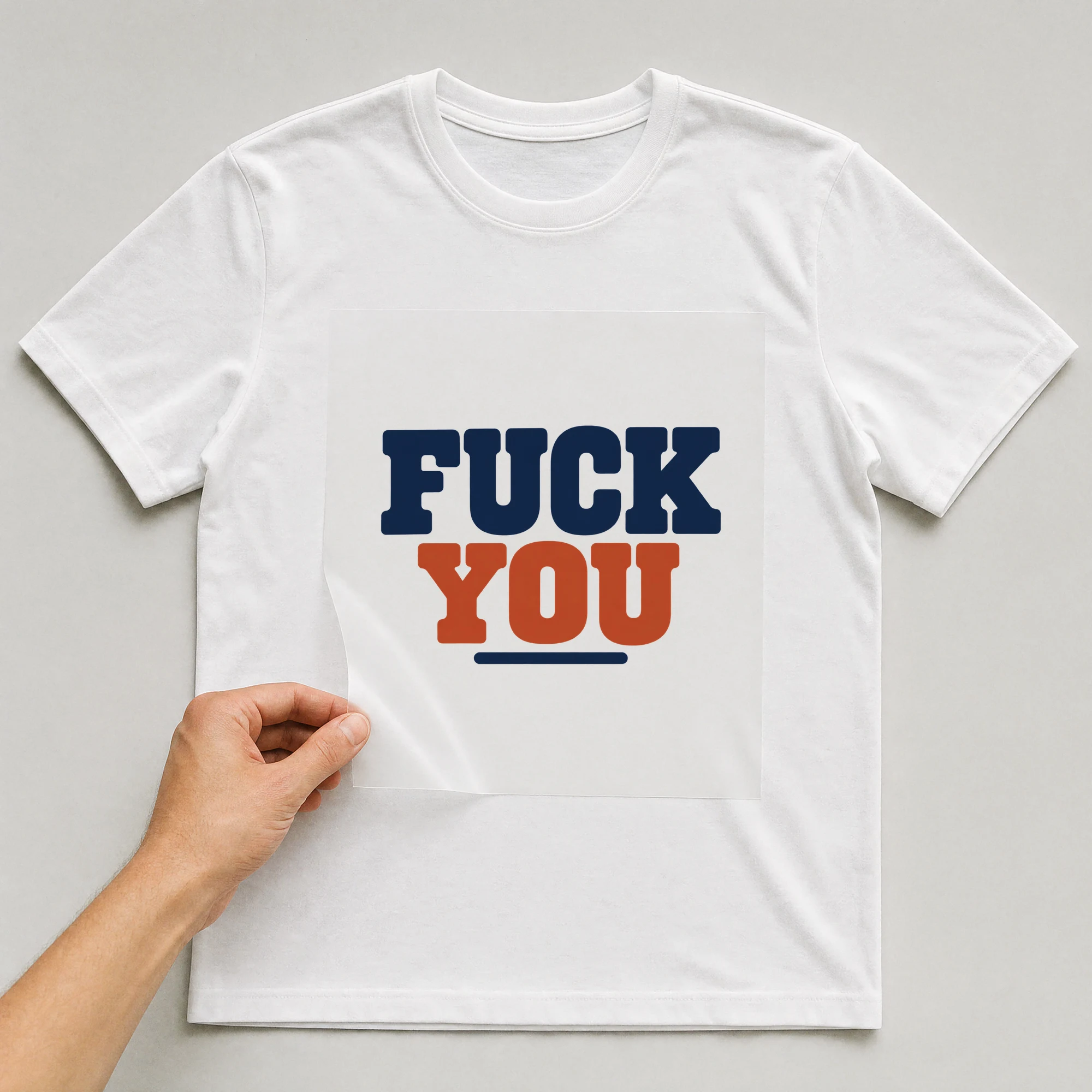 Bügelbild „F*ck You“ auf weißem T-Shirt, Folie wird aufgelegt