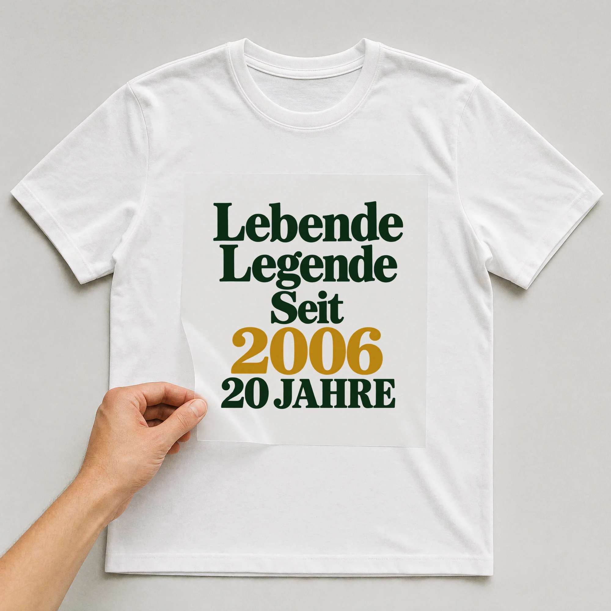 Bügelbild „Lebende Legende Seit 2006 20 JAHRE“ auf weißem T-Shirt, Folie wird aufgelegt
