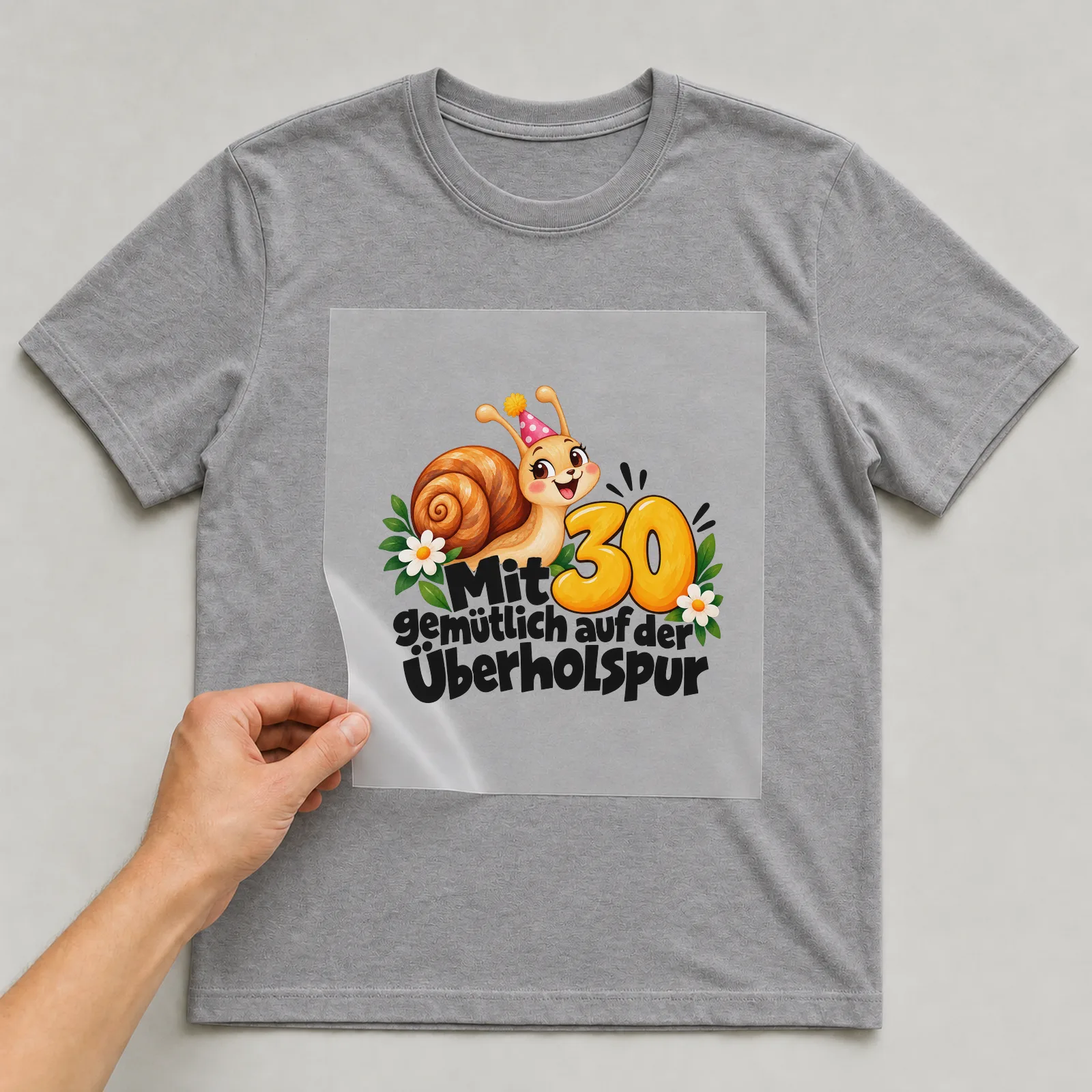Bügelbild „Mit 30 gemütlich auf der Überholspur“ auf grauem T-Shirt, Folie wird aufgelegt