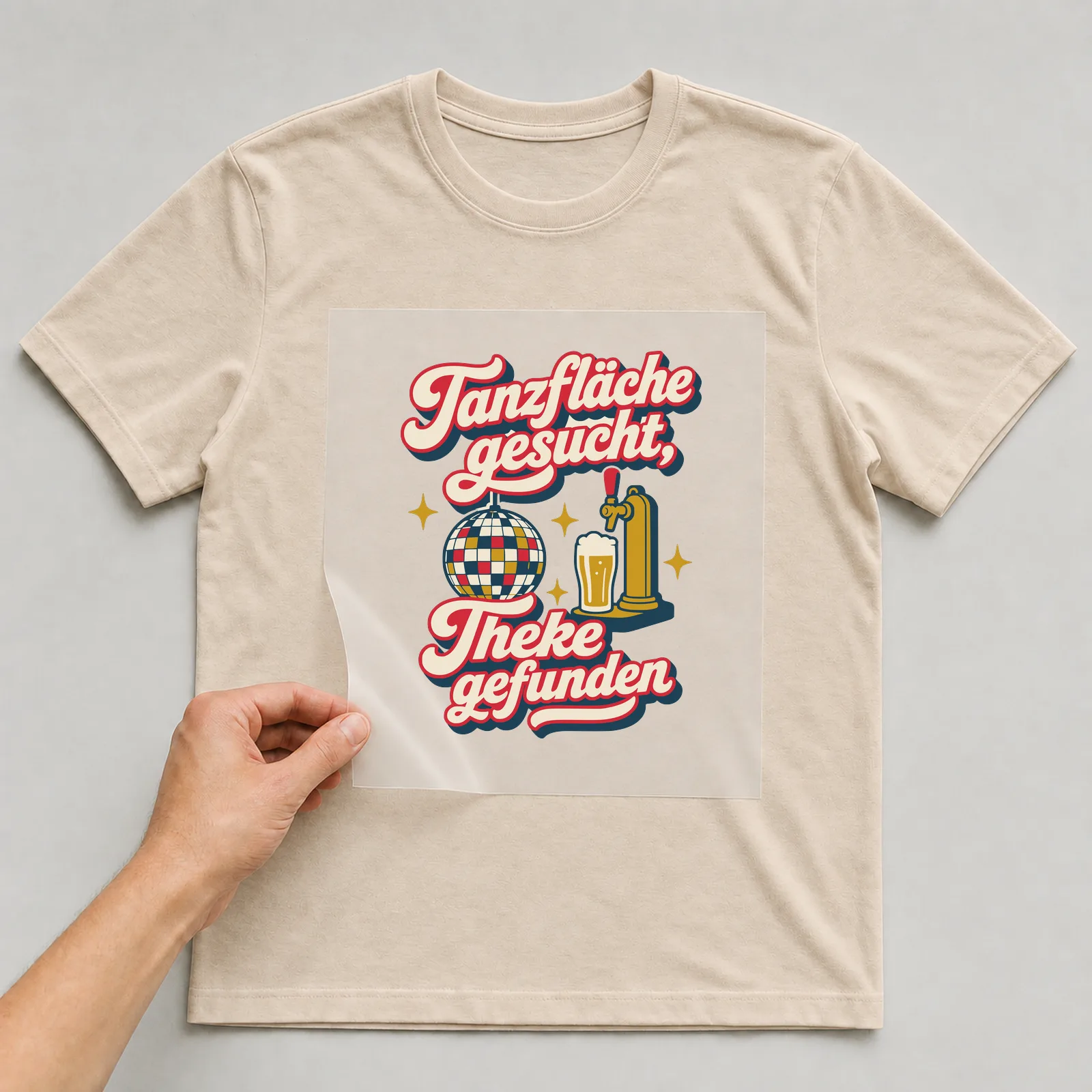 Bügelbild Tanzfläche gesucht, Theke gefunden auf beigem T-Shirt, Folie wird aufgelegt