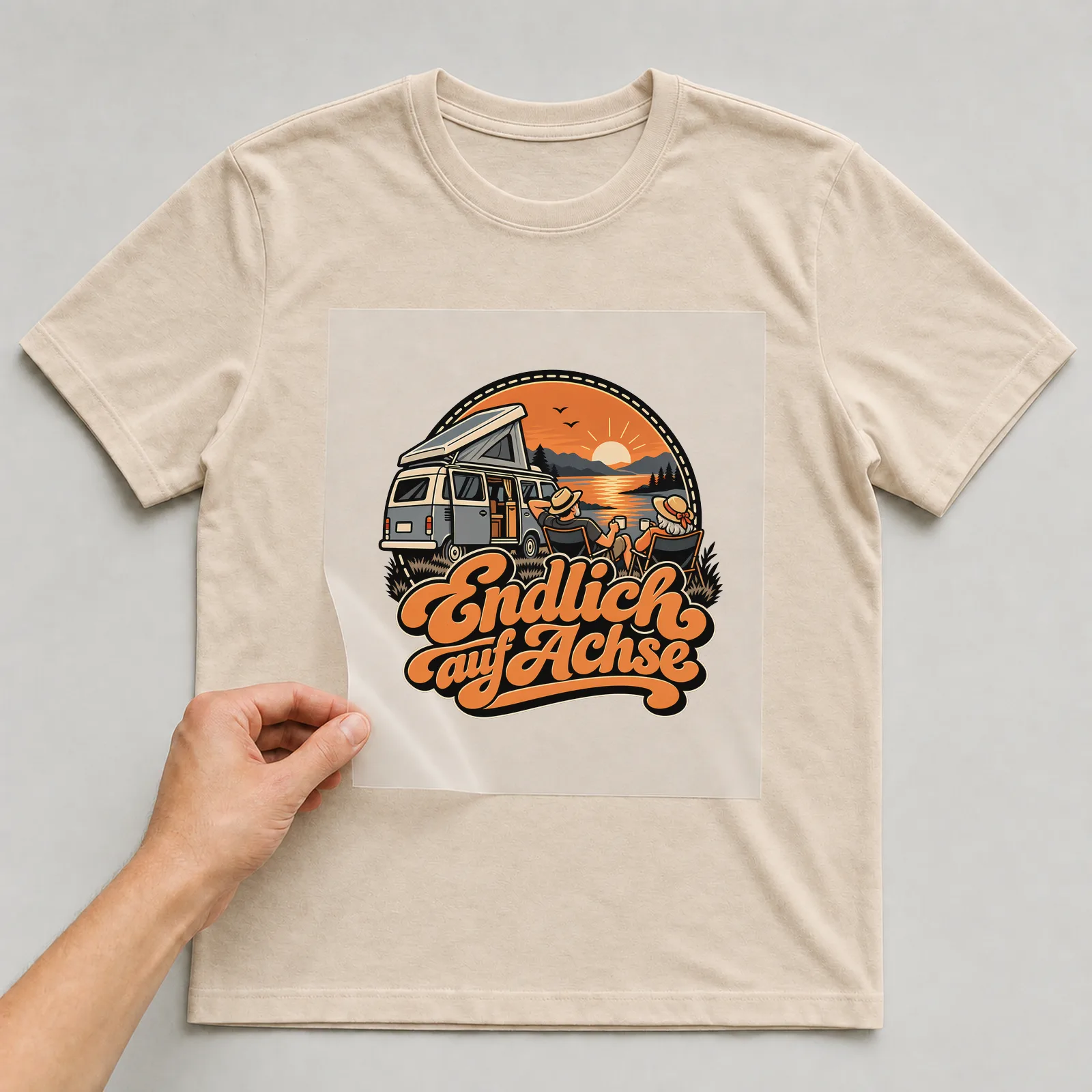 Bügelbild „Endlich auf Achse“ auf beigem T-Shirt, Folie wird aufgelegt
