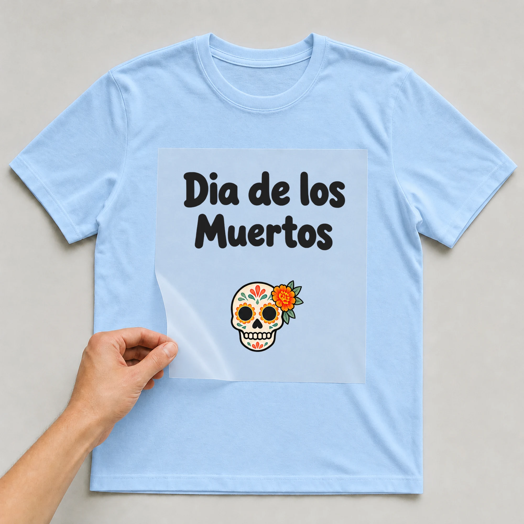 Bügelbild „Dia de los Muertos“ auf babyblauem T-Shirt, Folie wird aufgelegt