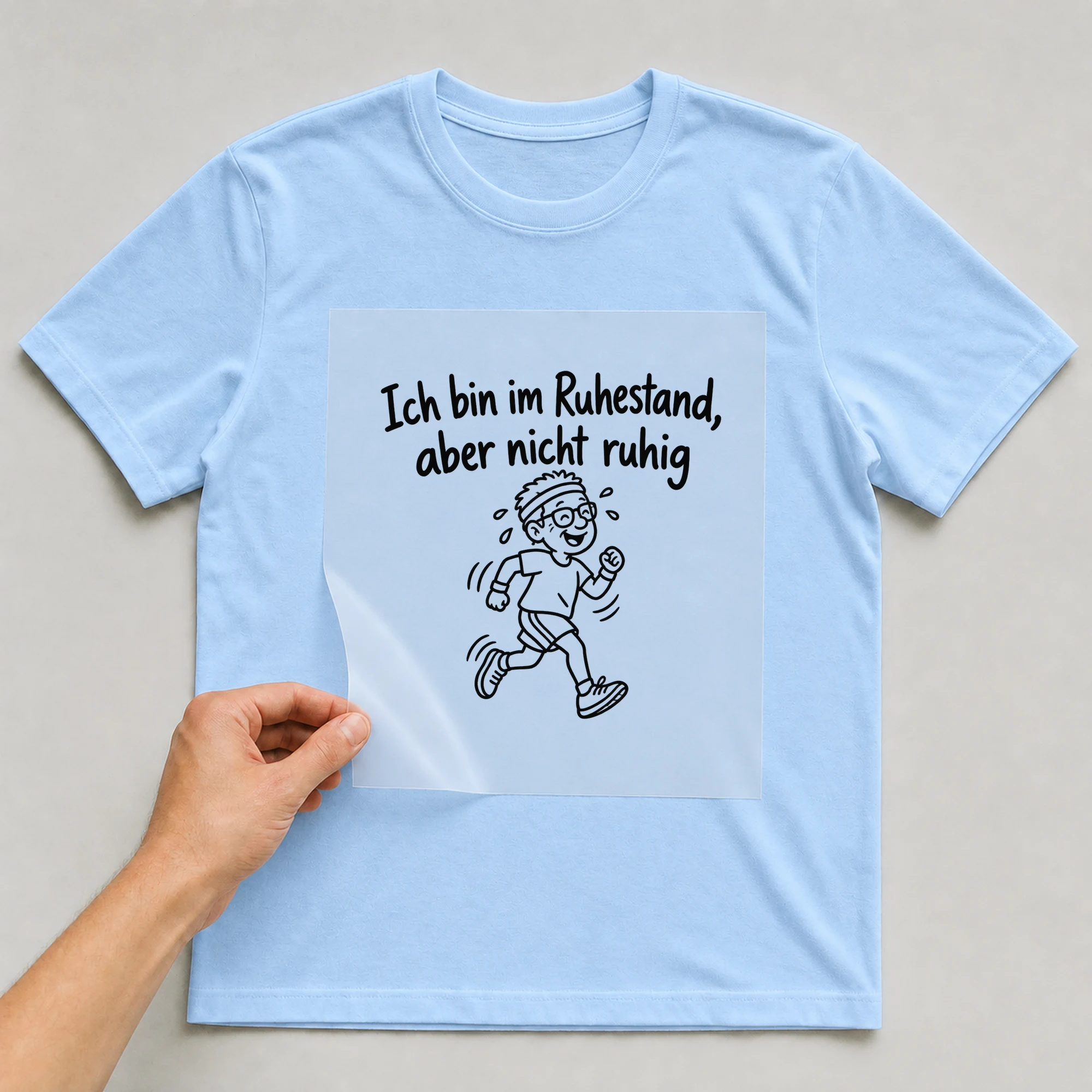 Bügelbild „Ich bin im Ruhestand, aber nicht ruhig“ auf babyblauem T-Shirt, Folie wird aufgelegt