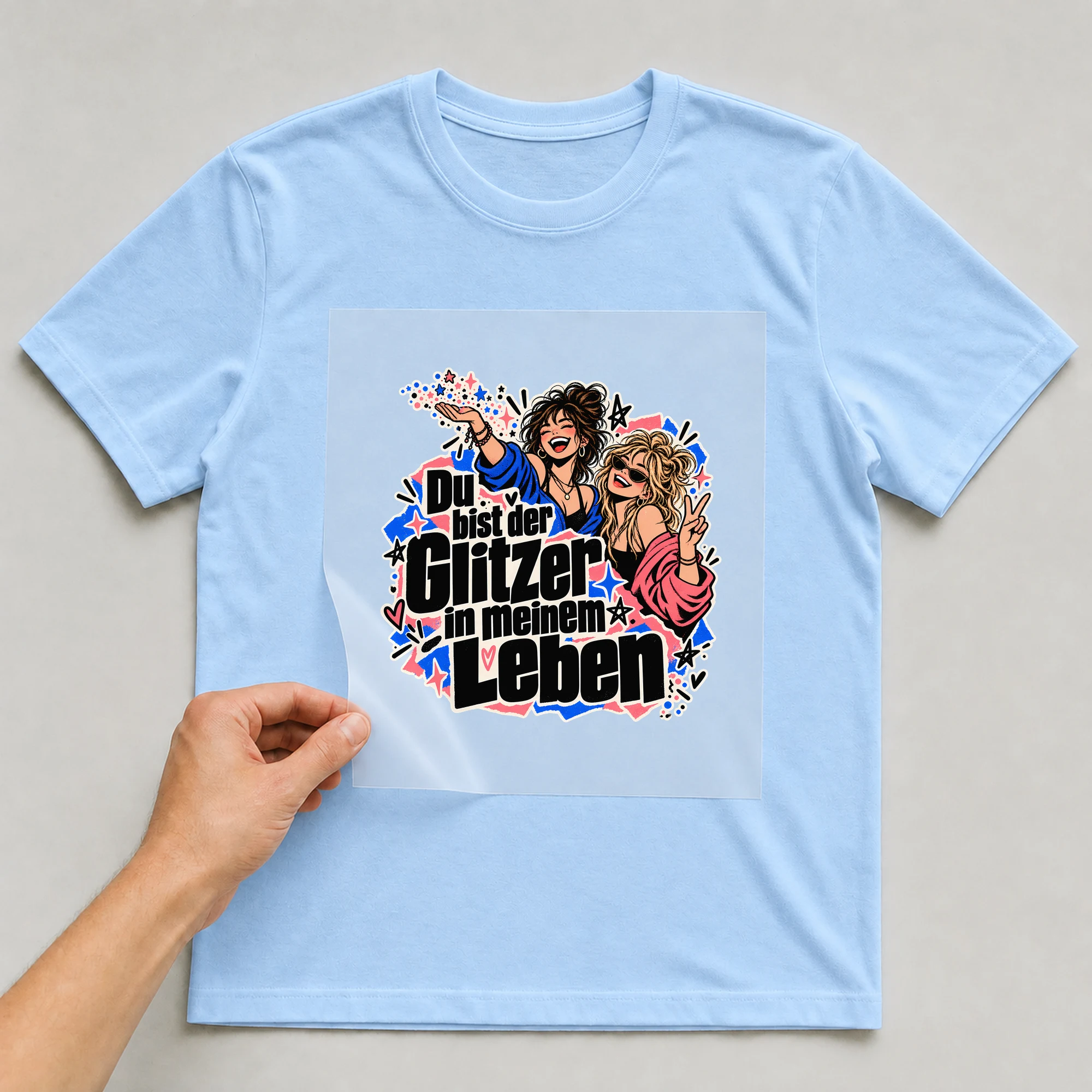 Bügelbild „Du bist der Glitzer in meinem Leben“ auf babyblauem T-Shirt, Folie wird aufgelegt